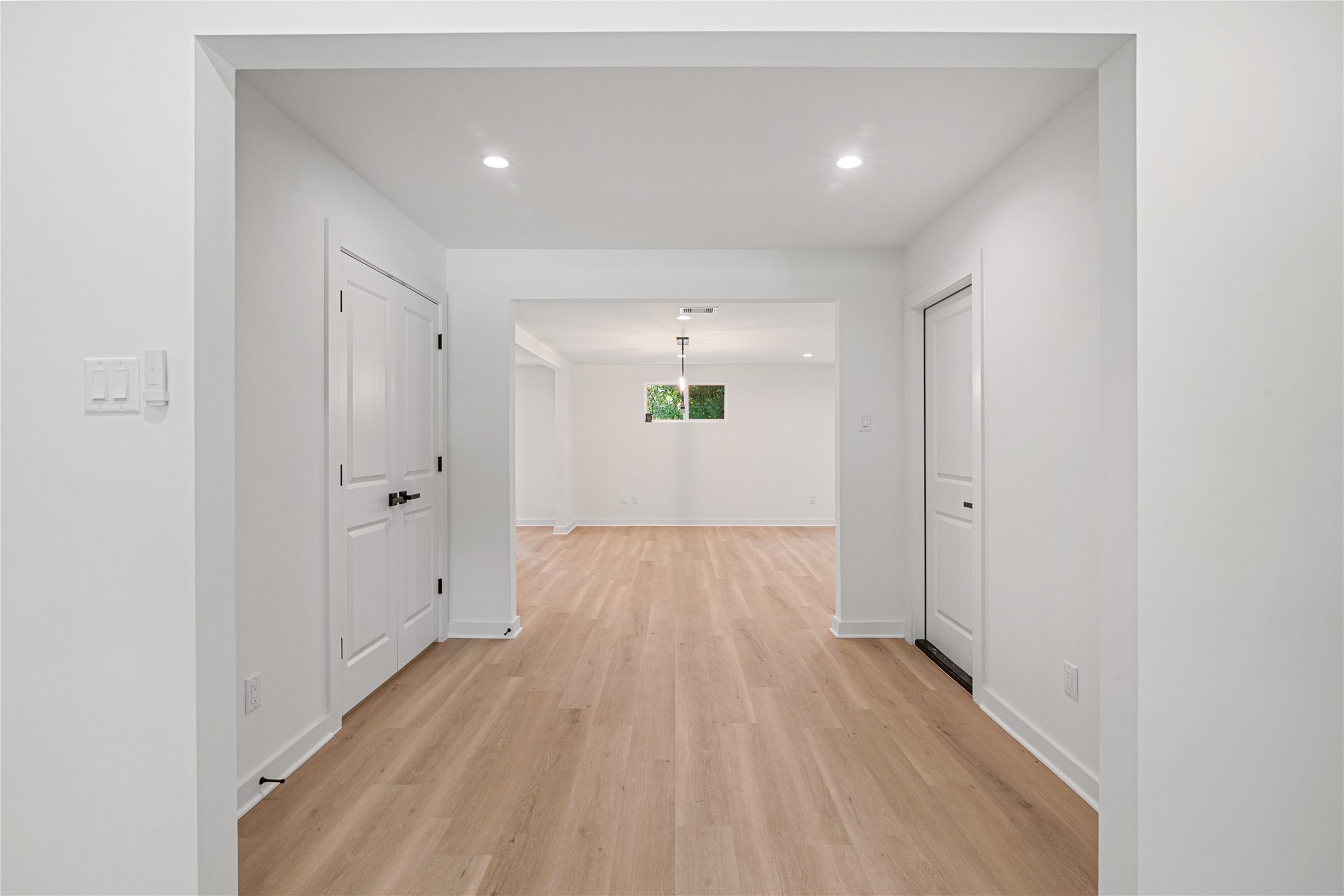 Freshly updated hallway with neutral finishes, recessed lighting, and access to adjoining rooms.