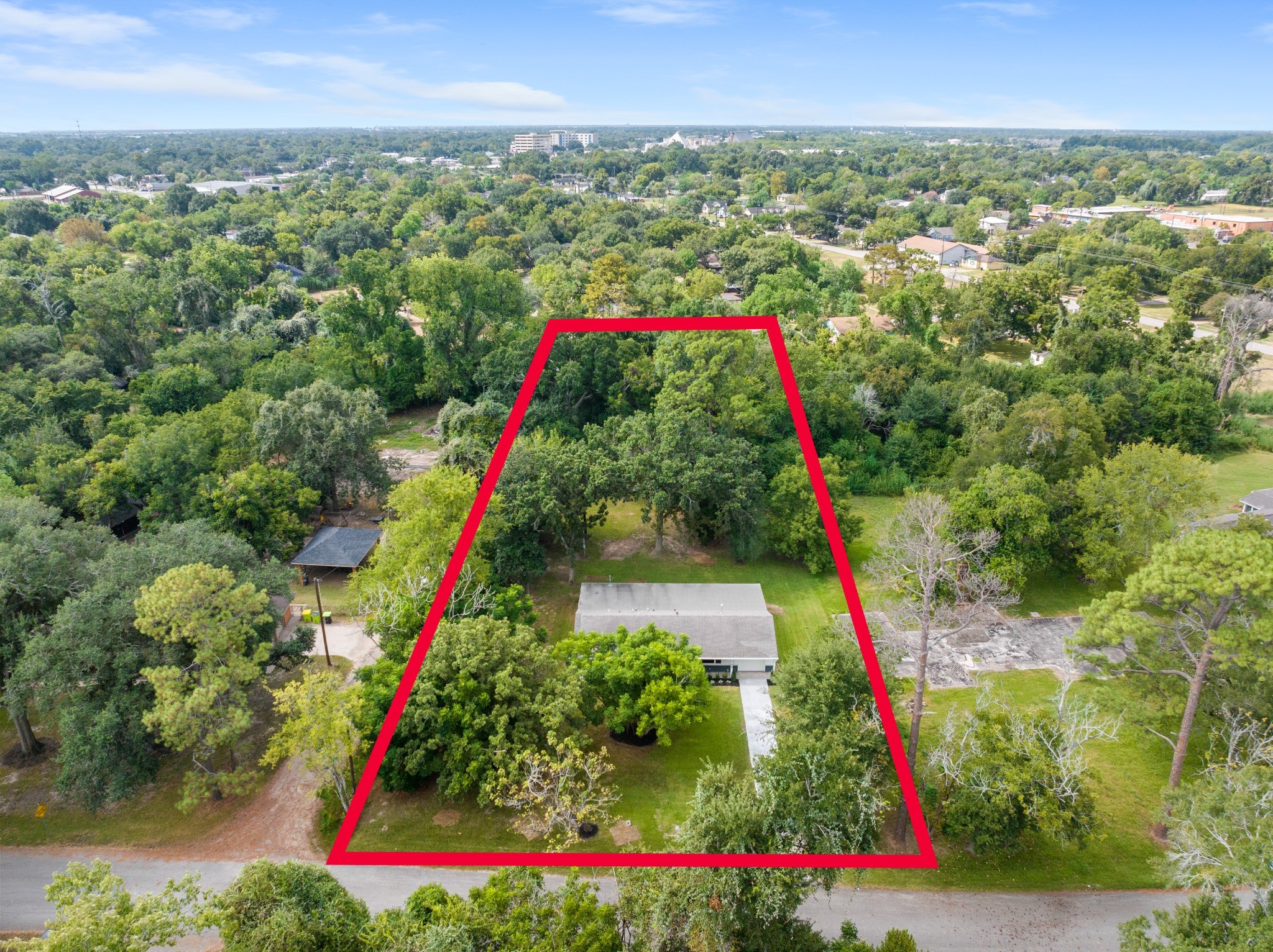 Aerial view with approximate property boundaries outlined in red, illustrating the impressive depth of the nearly one-acre lot.