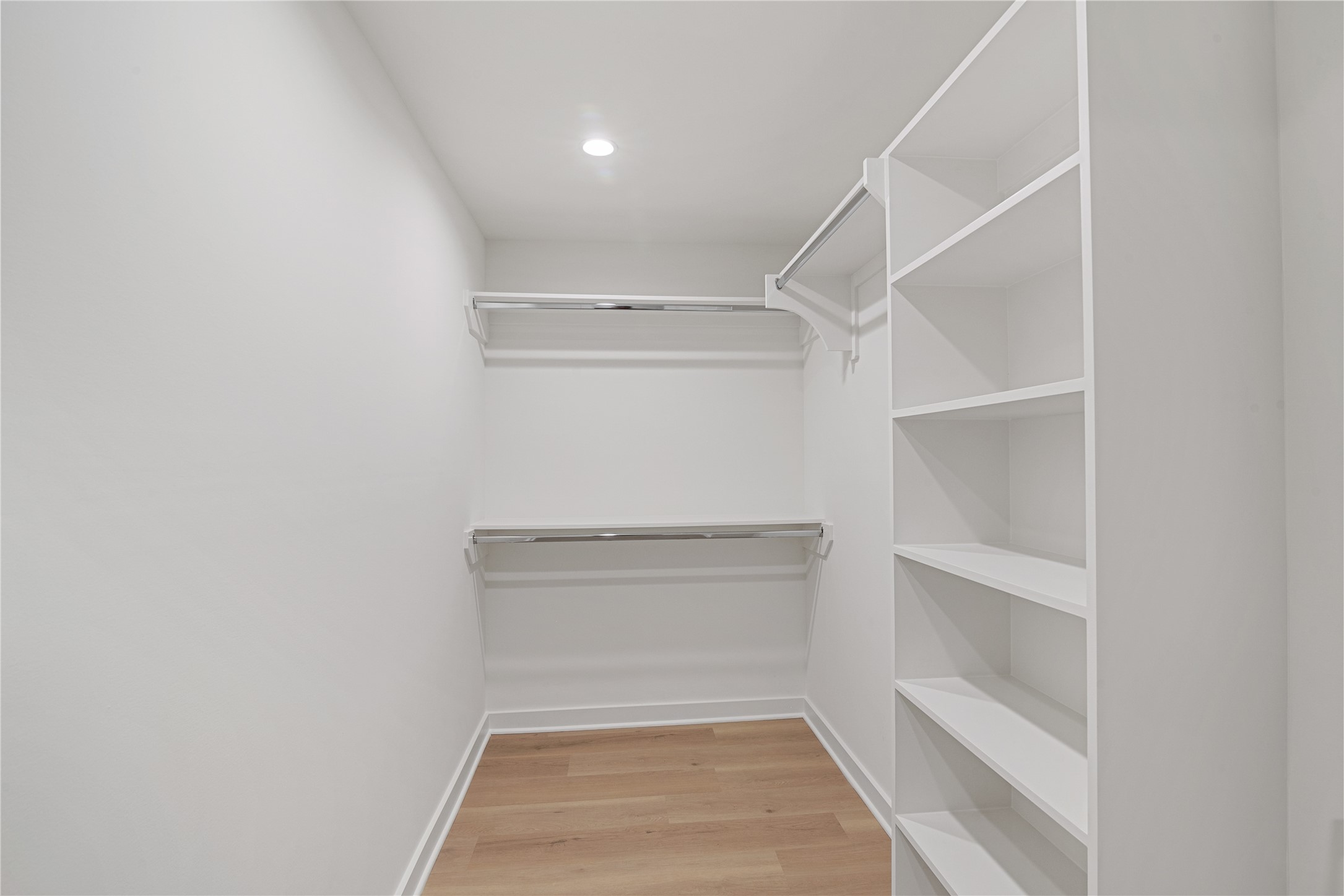 Generous walk-in closet with built-in shelving and hanging space for convenient storage and organization.