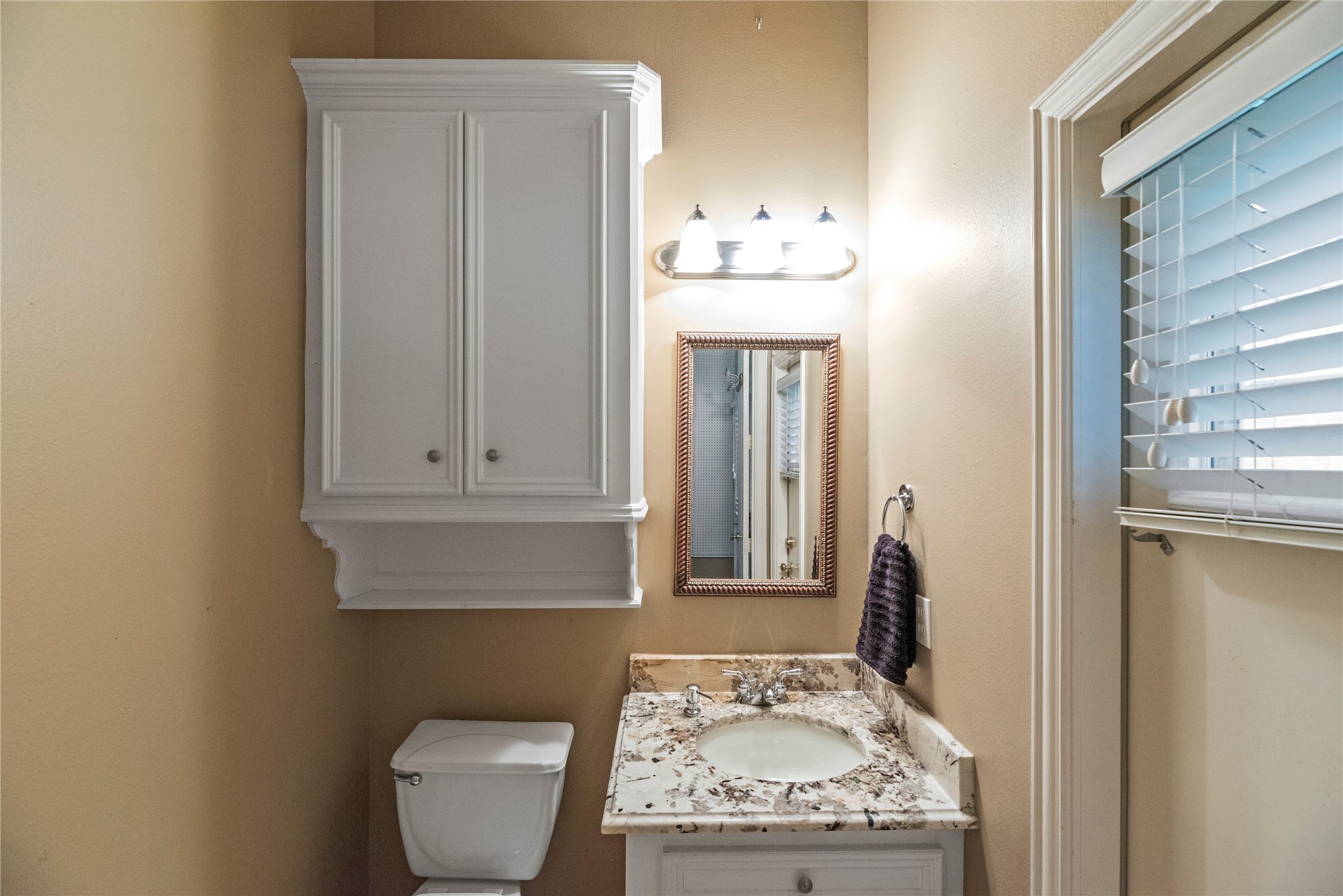Convenient half bathroom off the garage near the back patio.