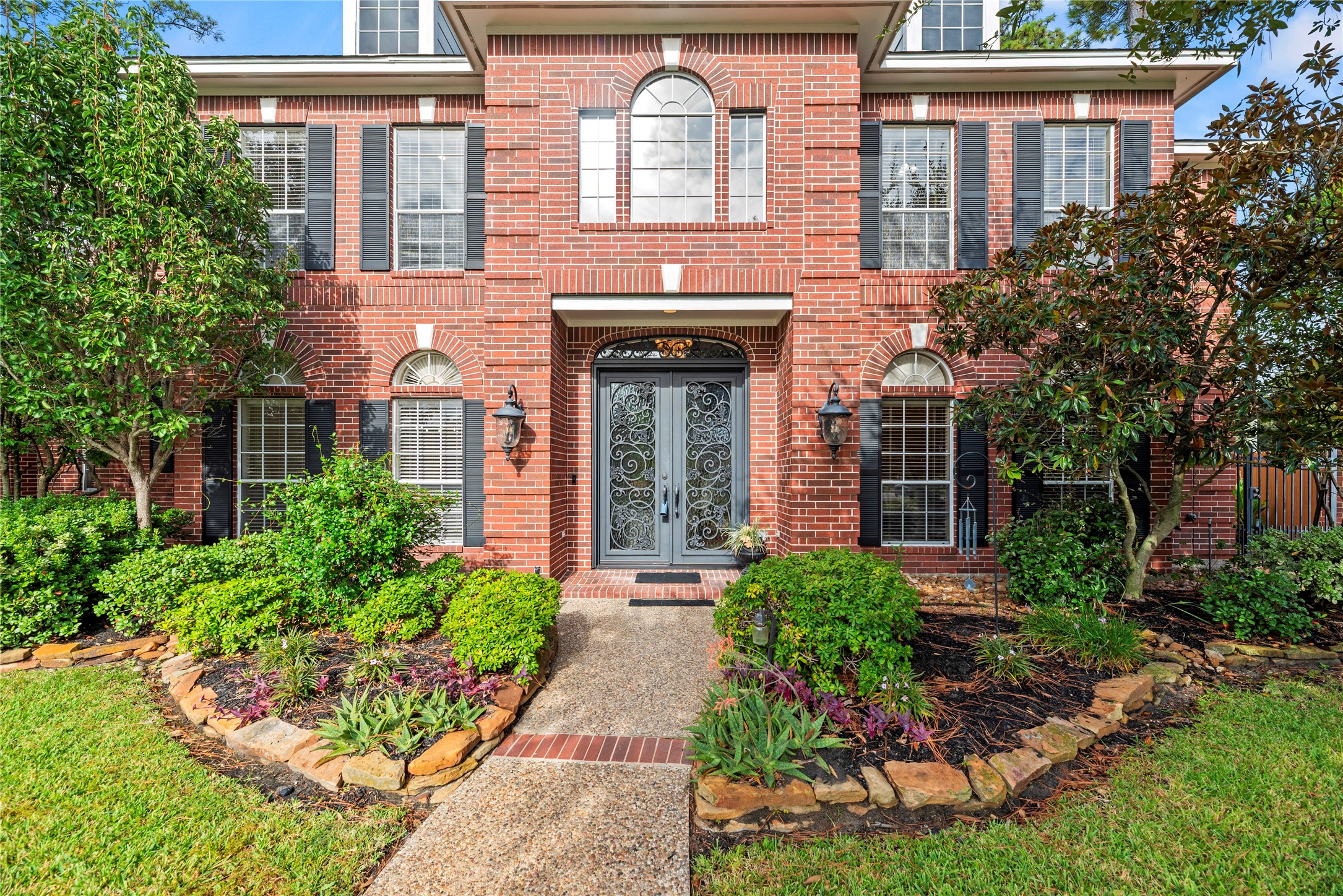 Stately 2-story home with a gorgeous brick elevation and lush landscaping.