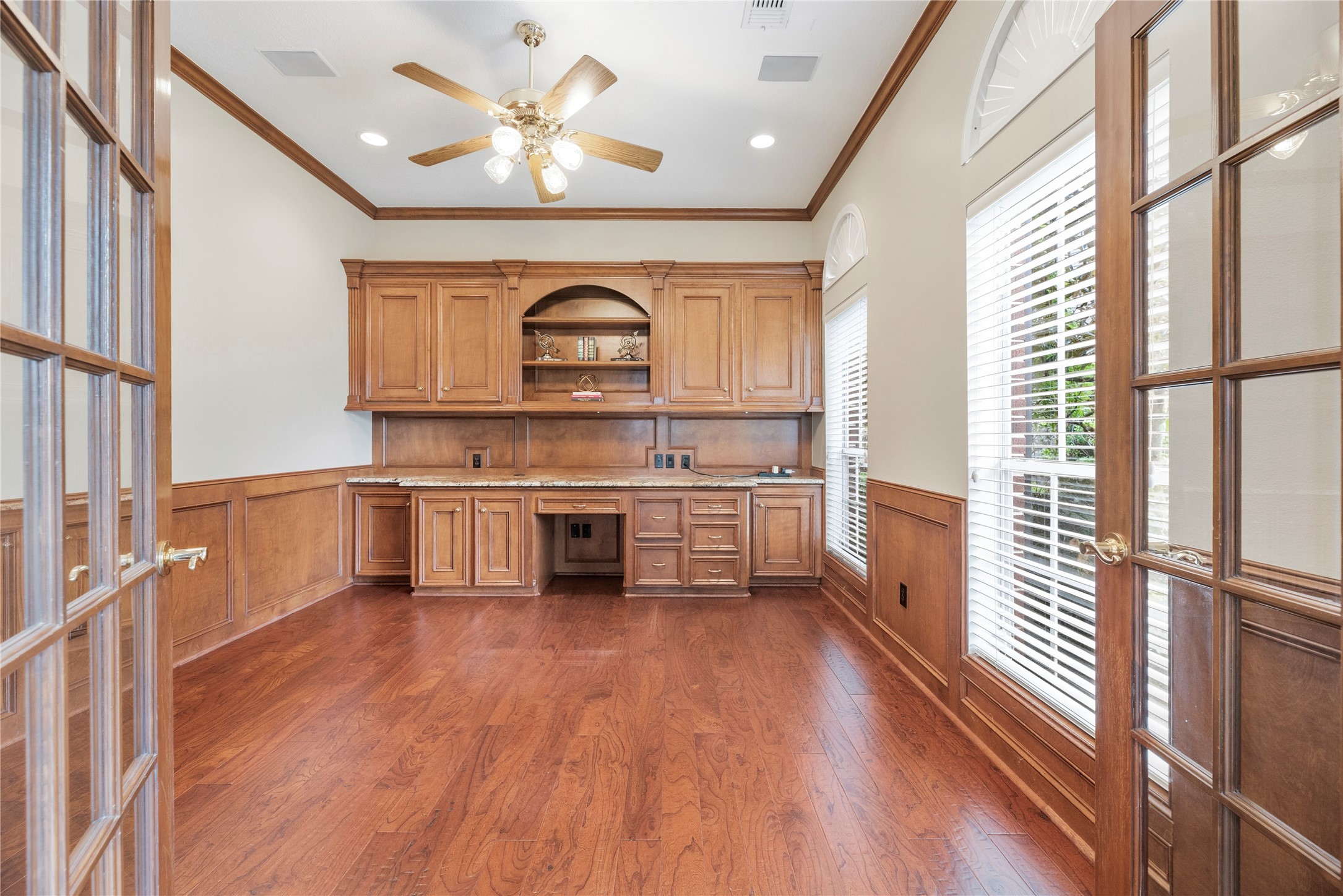 Handsome home office just off the entry with custom built-ins and French doors for privacy.