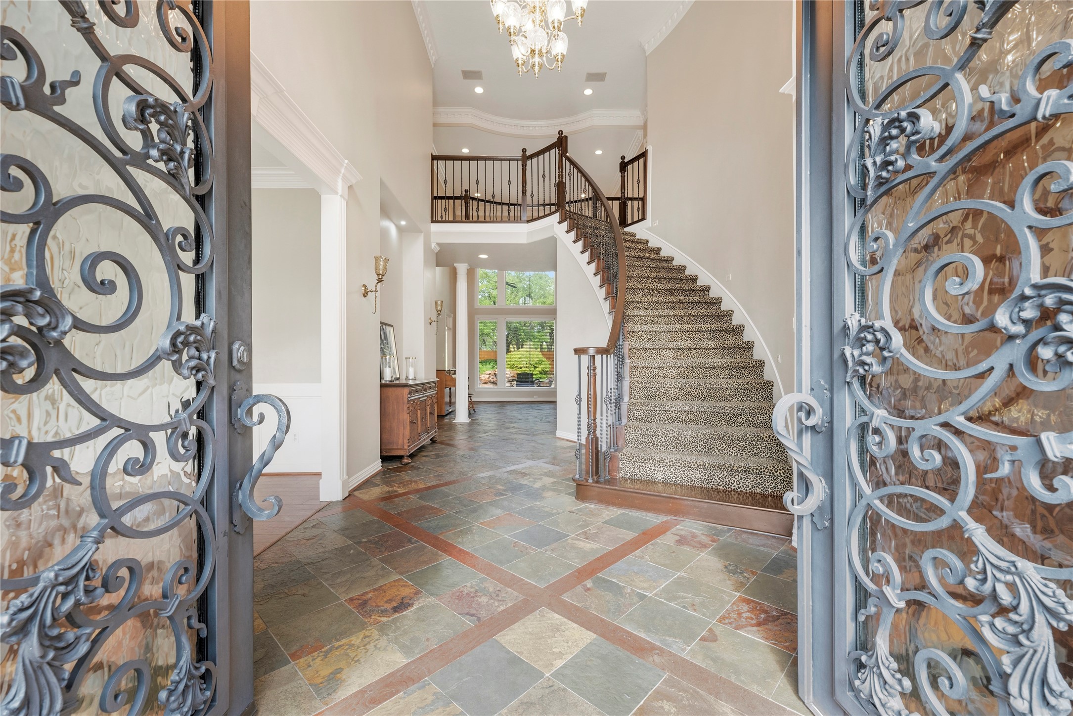 Stunning wrought iron double doors open to a grand foyer.