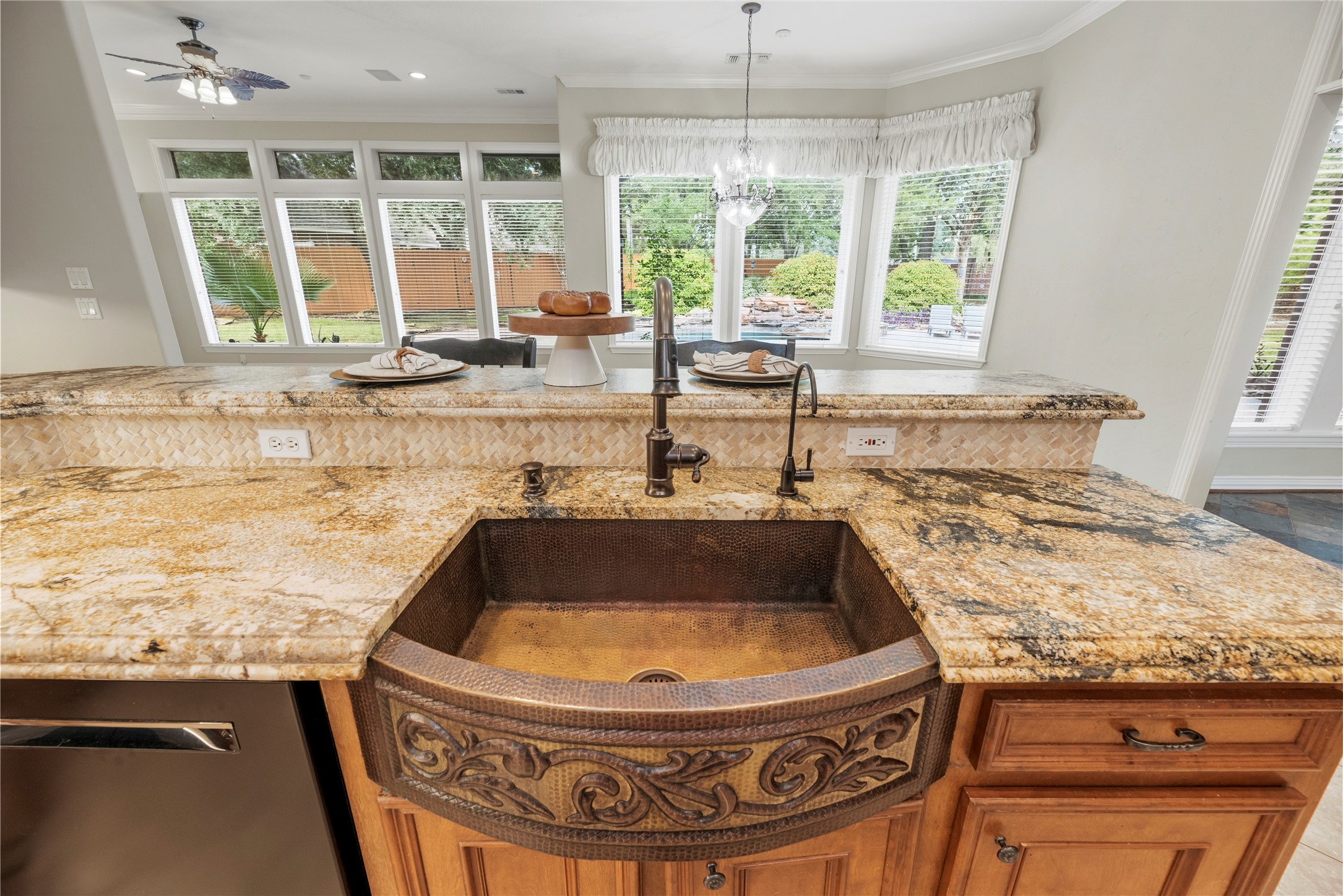 Stunning hammered copper farmhouse sink with ornate detailing.