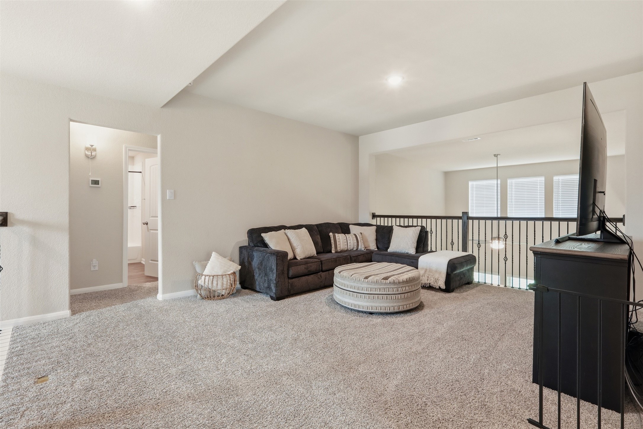 Spacious game room featuring abundant natural light, open sightlines to the living area below, and plenty of space for entertainment and recreation.
