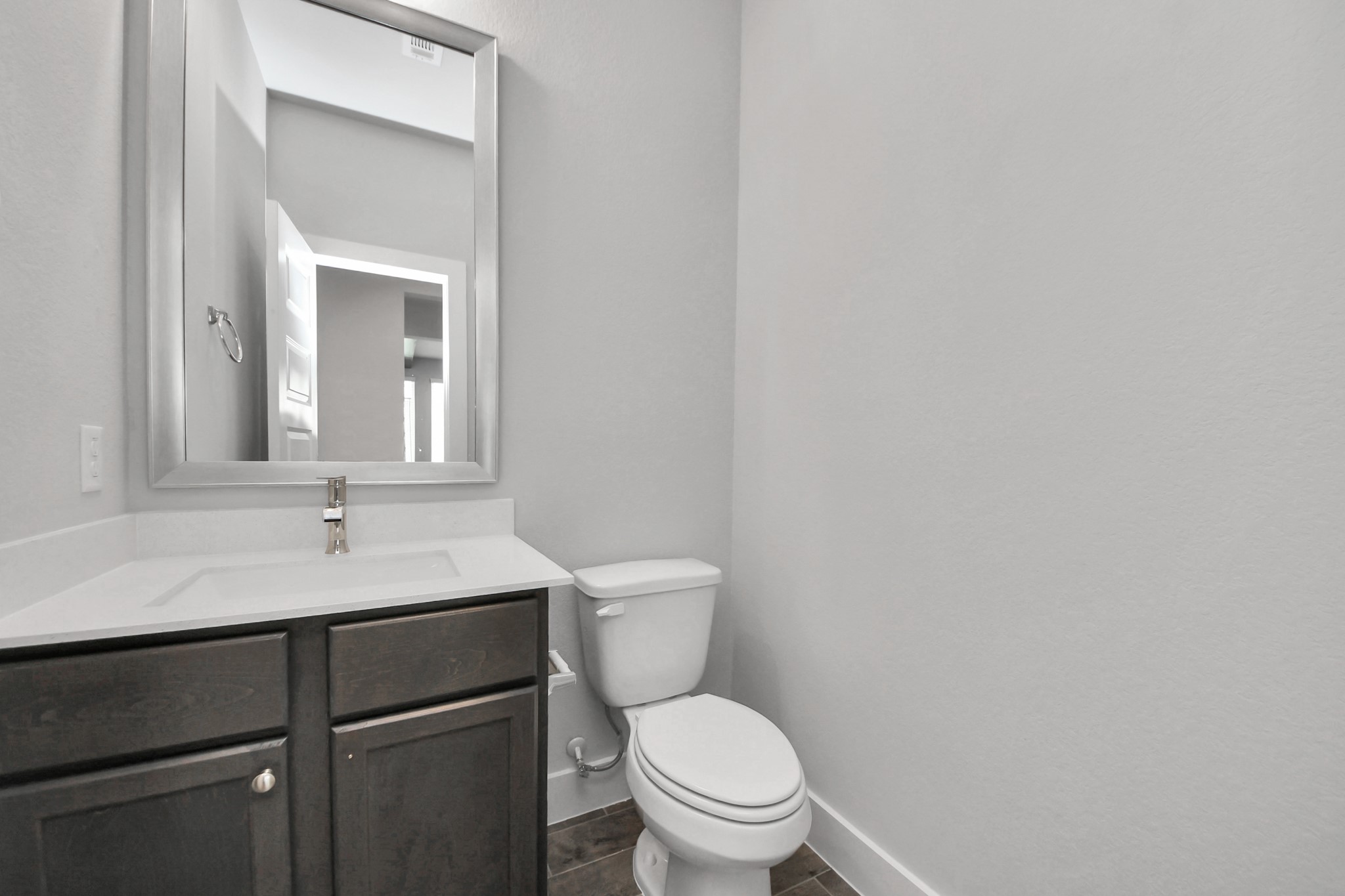 Sophisticated half bathroom adorned with contemporary finishes. The elegant 5-panel door welcomes you to a space where style meets functionality. Notice the sleek hardware accents that add a touch of modern charm. The vanity boasts light-colored countertops, beautifully complemented by a tasteful vanity light, creating a well-lit and inviting atmosphere. Sample photo of completed home with similar floor plan. Actual colors and selections may vary. Sophisticated half bathroom adorned with contemporary finishes. The elegant 5-panel door welcomes you to a space where style meets functionality. Notice the sleek hardware accents that add a touch of modern charm. The vanity boasts light-colored countertops, beautifully complemented by a tasteful vanity light, creating a well-lit and inviting atmosphere. Sample photo of completed home with similar floor plan. Actual colors and selections may vary.