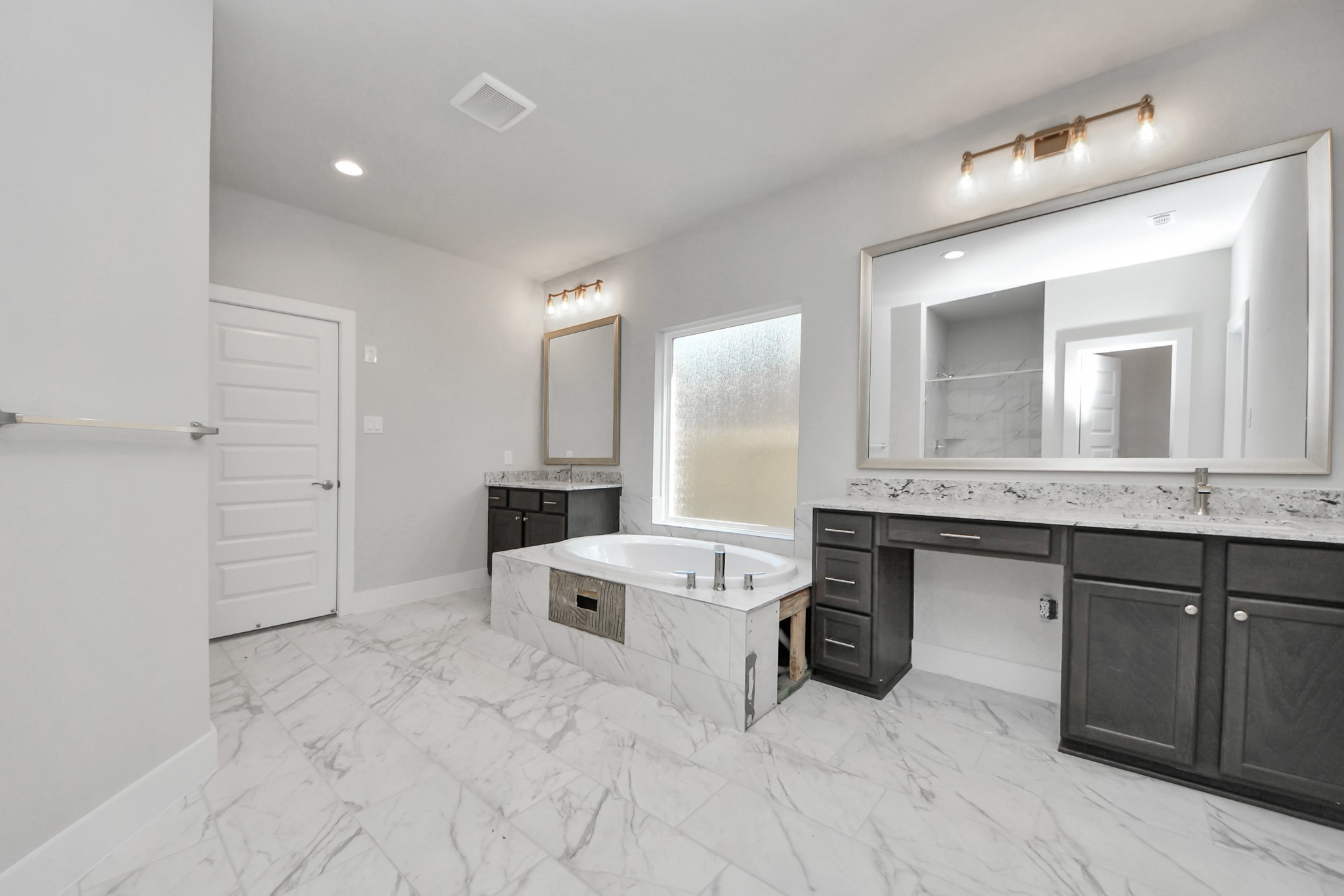 Elevate your daily routine at the elegant vanity, now equipped with double sinks, light countertops, modern hardware, and beautiful vanity lights. Sample photo of completed home with similar floor plan. Actual colors and selections may vary.