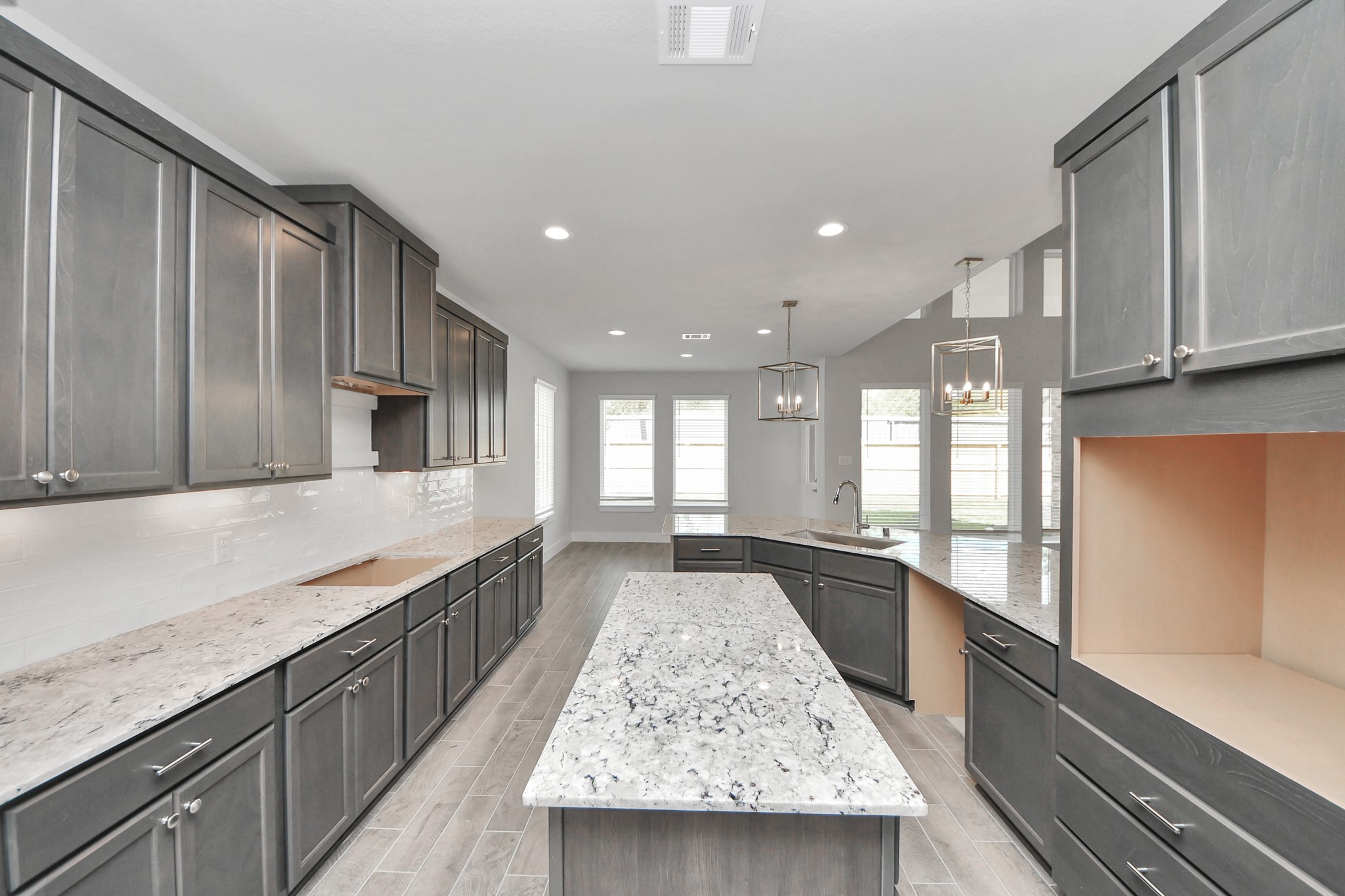 The kitchen is a culinary haven, featuring granite countertops, a tile backsplash, stainless steel appliances, 42 upper cabinets, and undercabinet lighting. Sample photo of completed home with similar floor plan. Actual colors and selections may vary. The kitchen is a culinary haven, featuring granite countertops, a tile backsplash, stainless steel appliances, 42 upper cabinets, and undercabinet lighting. Sample photo of completed home with similar floor plan. Actual colors and selections may vary.