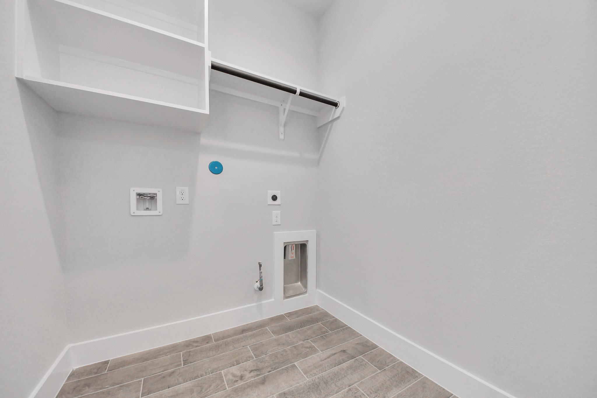 A perfect blend of functionality and comfort. Capture the essence of easy living with a first-floor laundry room, thoughtfully equipped with shelving for effortless organization. Both electric and gas connections available. Sample photo of completed home with similar floor plan. Actual colors and selections may vary.