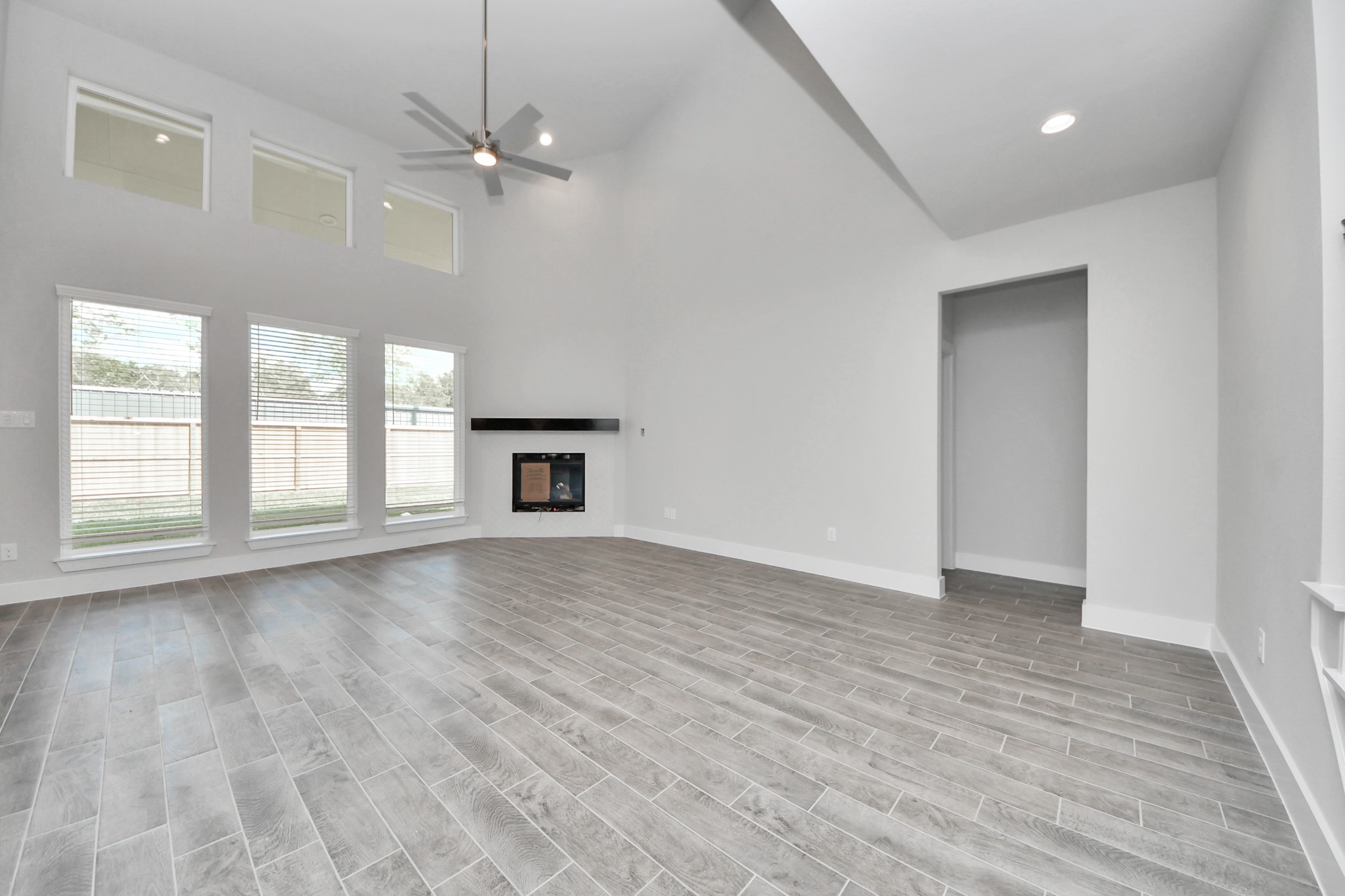 Welcome family and guests to your charming living room! With its high ceilings, recessed lighting, ceiling fan, custom paint, beautiful flooring, and large windows that let in abundant natural light, this room is perfect for gatherings. Sample photo of completed home with similar floor plan. Actual colors and selections may vary.