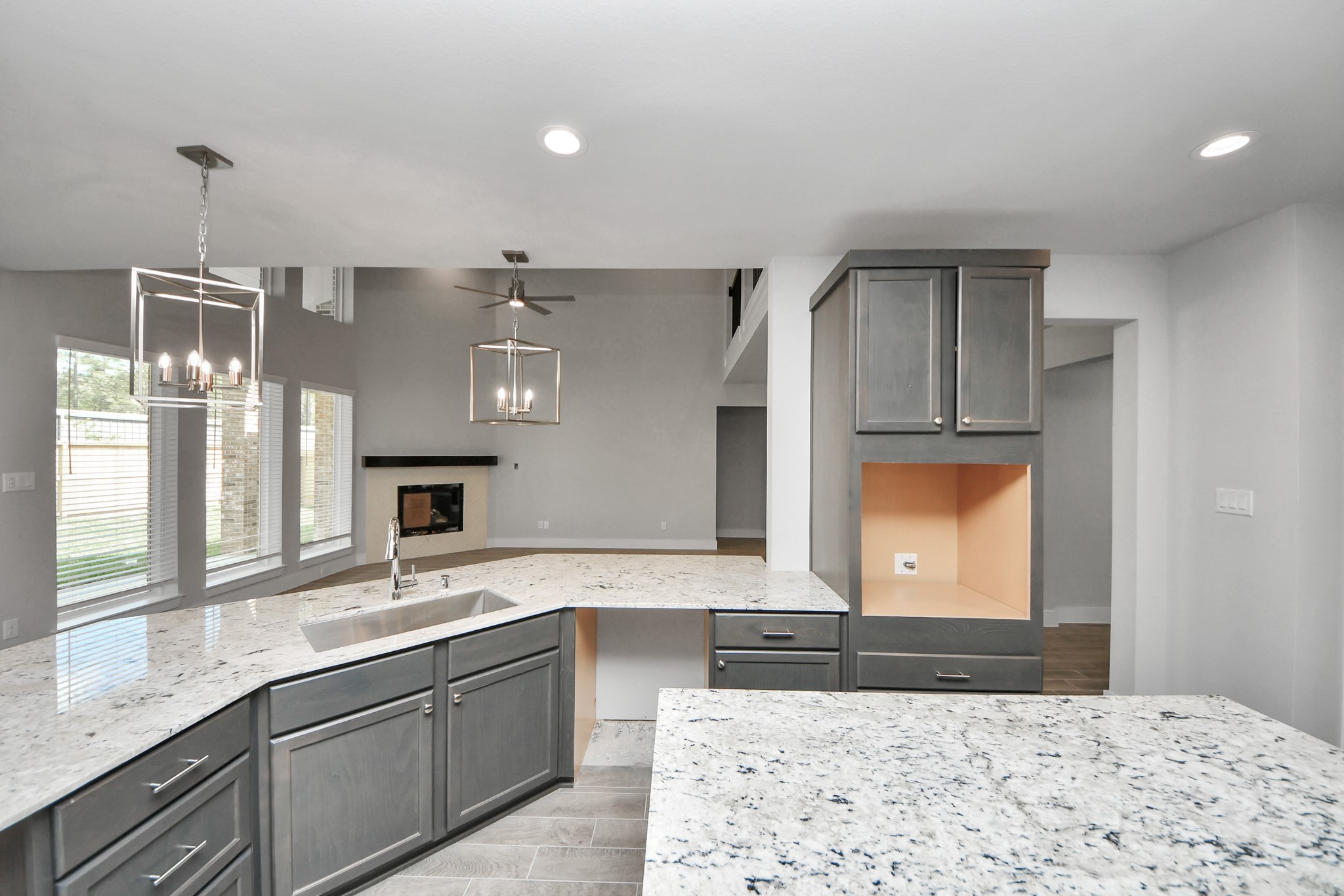This kitchen is truly a chef's dream! This haven Boasts high ceilings, recessed & pendant lighting, stained wood cabinets, granite countertops, stainless steel appliances, a modern tile backsplash. All of this overlooks your expansive family room, creating a perfect space for culinary delights and family gatherings. Sample photo of completed home with similar floor plan. Actual colors and selections may vary. This kitchen is truly a chef's dream! This haven Boasts high ceilings, recessed & pendant lighting, stained wood cabinets, granite countertops, stainless steel appliances, a modern tile backsplash. All of this overlooks your expansive family room, creating a perfect space for culinary delights and family gatherings. Sample photo of completed home with similar floor plan. Actual colors and selections may vary.