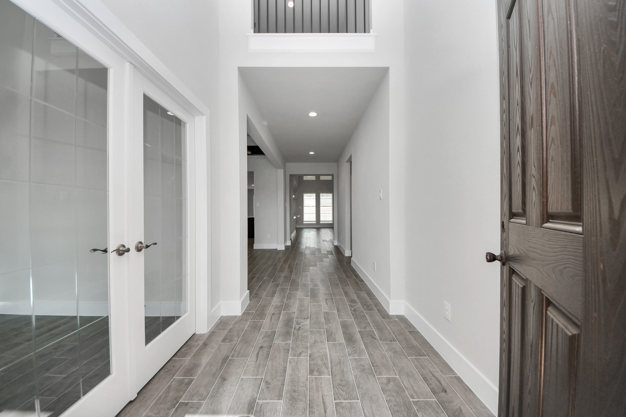 As you step into the threshold of this luxurious home, you'll soon be welcomed by an elegant glass door (to be installed). Inside, soaring ceilings amplify the spaciousness, while the refined wood-look tile flooring and oversized baseboards exude sophistication and charm. Sample photo of completed home with similar floor plan. Actual colors and selections may vary. As you step into the threshold of this luxurious home, you'll soon be welcomed by an elegant glass door (to be installed). Inside, soaring ceilings amplify the spaciousness, while the refined wood-look tile flooring and oversized baseboards exude sophistication and charm. Sample photo of completed home with similar floor plan. Actual colors and selections may vary.