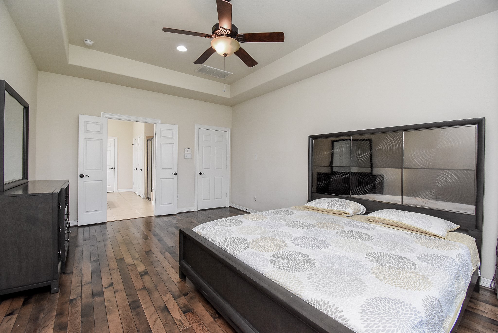 Alternate view of the primary bedroom, with the tray ceiling and french doors it gives you added elegance throughout the room.