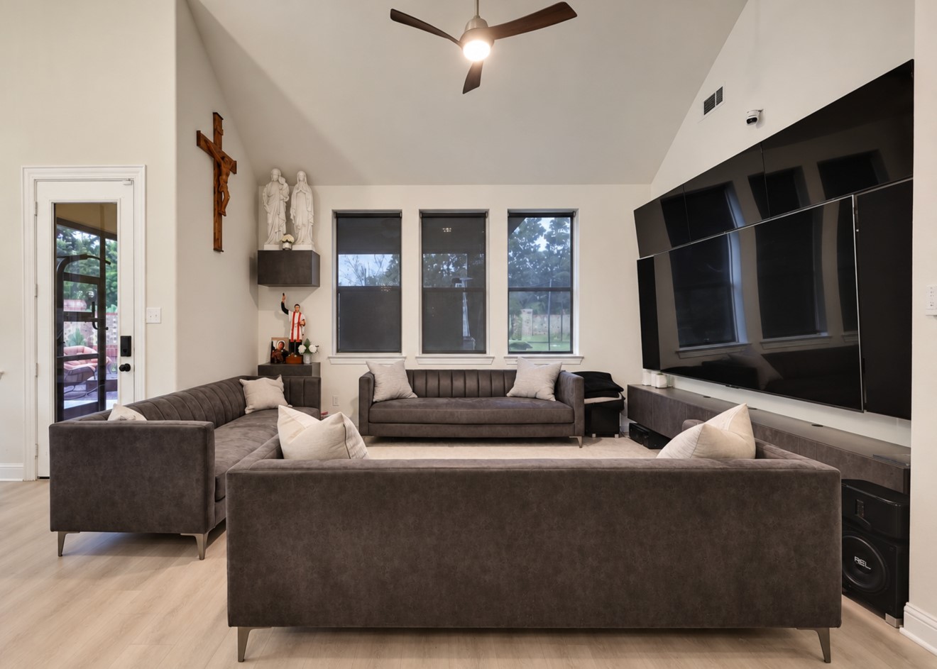 Inviting living area featuring high ceilings, updated flooring, and abundant natural light. The open layout connects to the kitchen and dining area for easy everyday living and entertaining, with convenient access to the staircase leading upstairs.