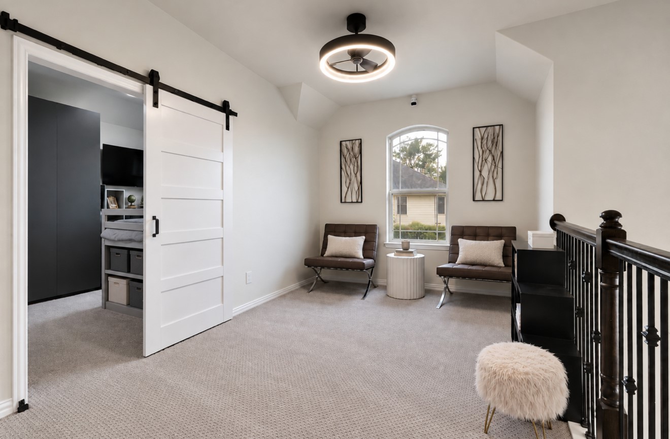 The upstairs staircase opens directly into a spacious game room, offering a versatile setting for recreation, relaxation, or entertaining. To the left, a separate office with a sliding door provides a dedicated space for work or study.