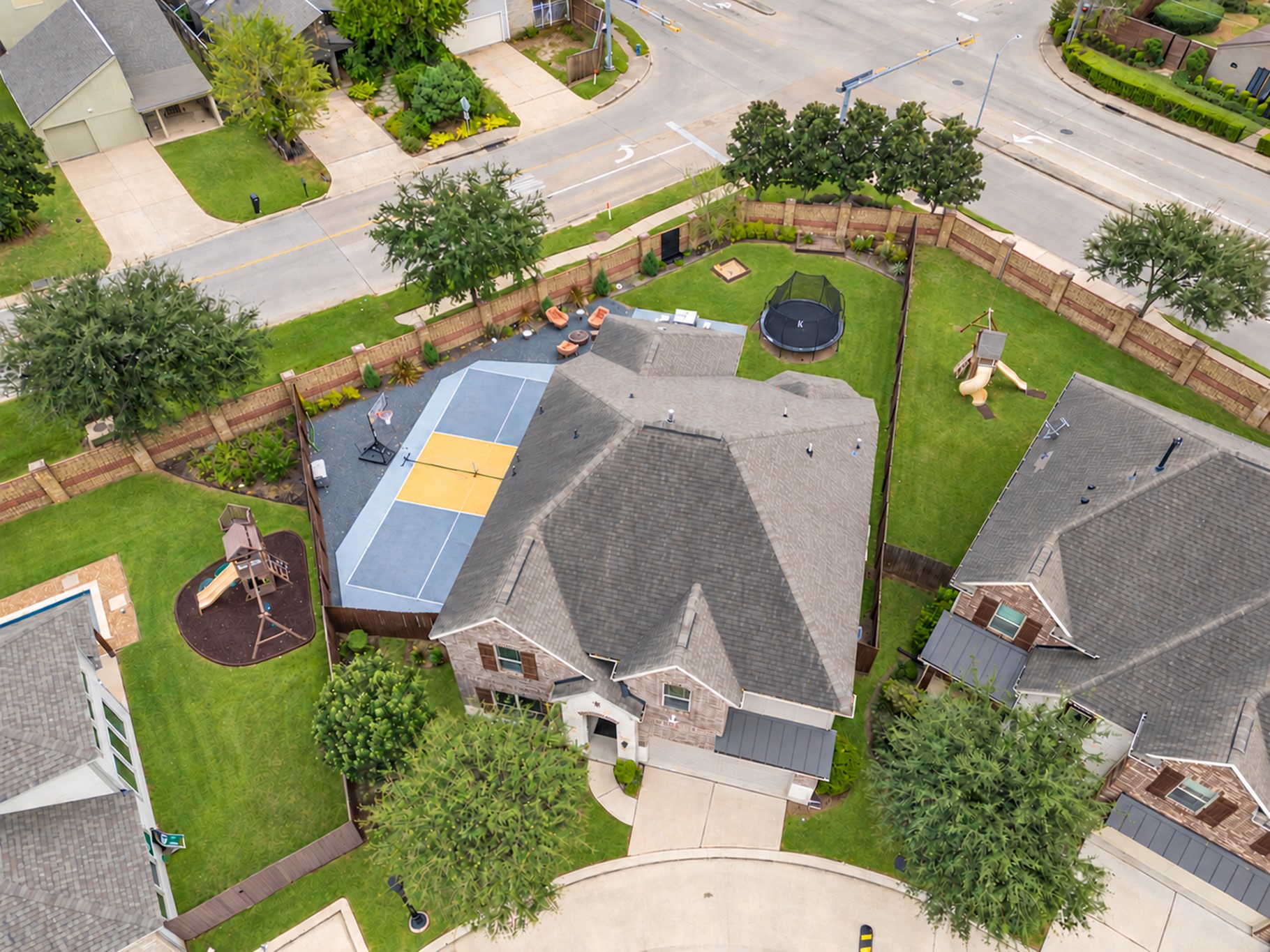 Enjoy your own private recreation retreat in this spacious backyard, featuring a screened-in covered patio, a multipurpose pickleball or basketball court, an expanded patio, and plenty of green space for outdoor fun and entertaining!