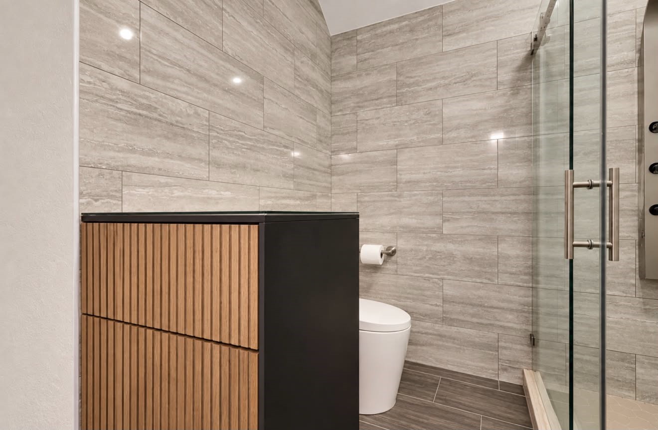 Fully renovated upstairs Jack-and-Jill bathroom featuring updated finishes, a walk-in shower, and convenient access from both adjoining bedrooms, combining style with everyday functionality.