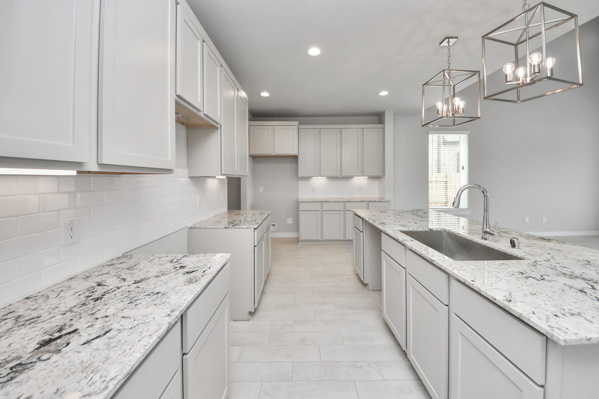 The kitchen is a culinary haven, featuring granite countertops, a tile backsplash, stainless steel appliances, 42 upper cabinets, and undercabinet lighting. Sample photo of completed home with similar floor plan. Actual colors and selections may vary.