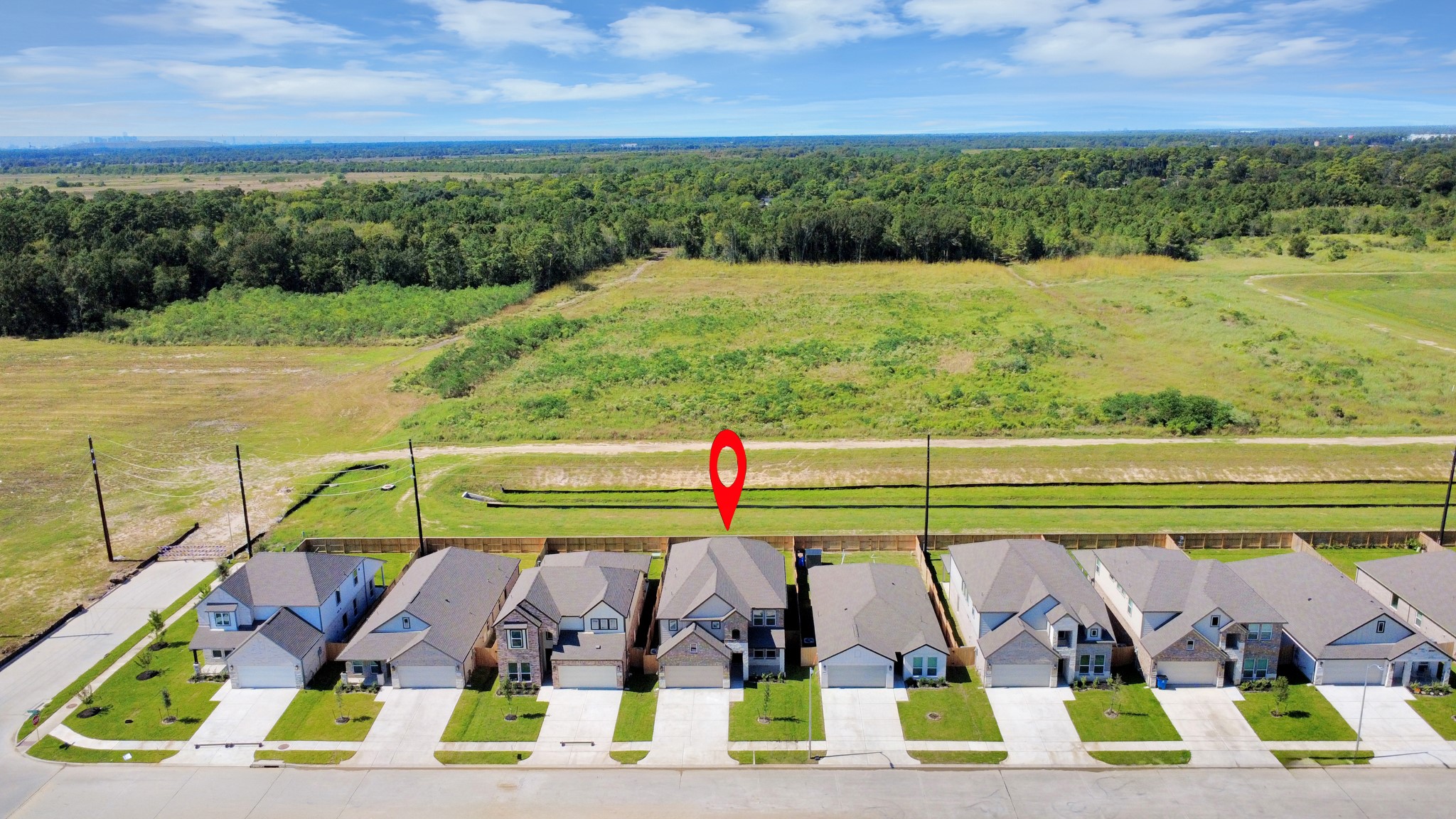 An aerial view of a spacious subdivision lot, highlighting a well-maintained yard and a fully fenced perimeter, offering both privacy and expansive outdoor space.