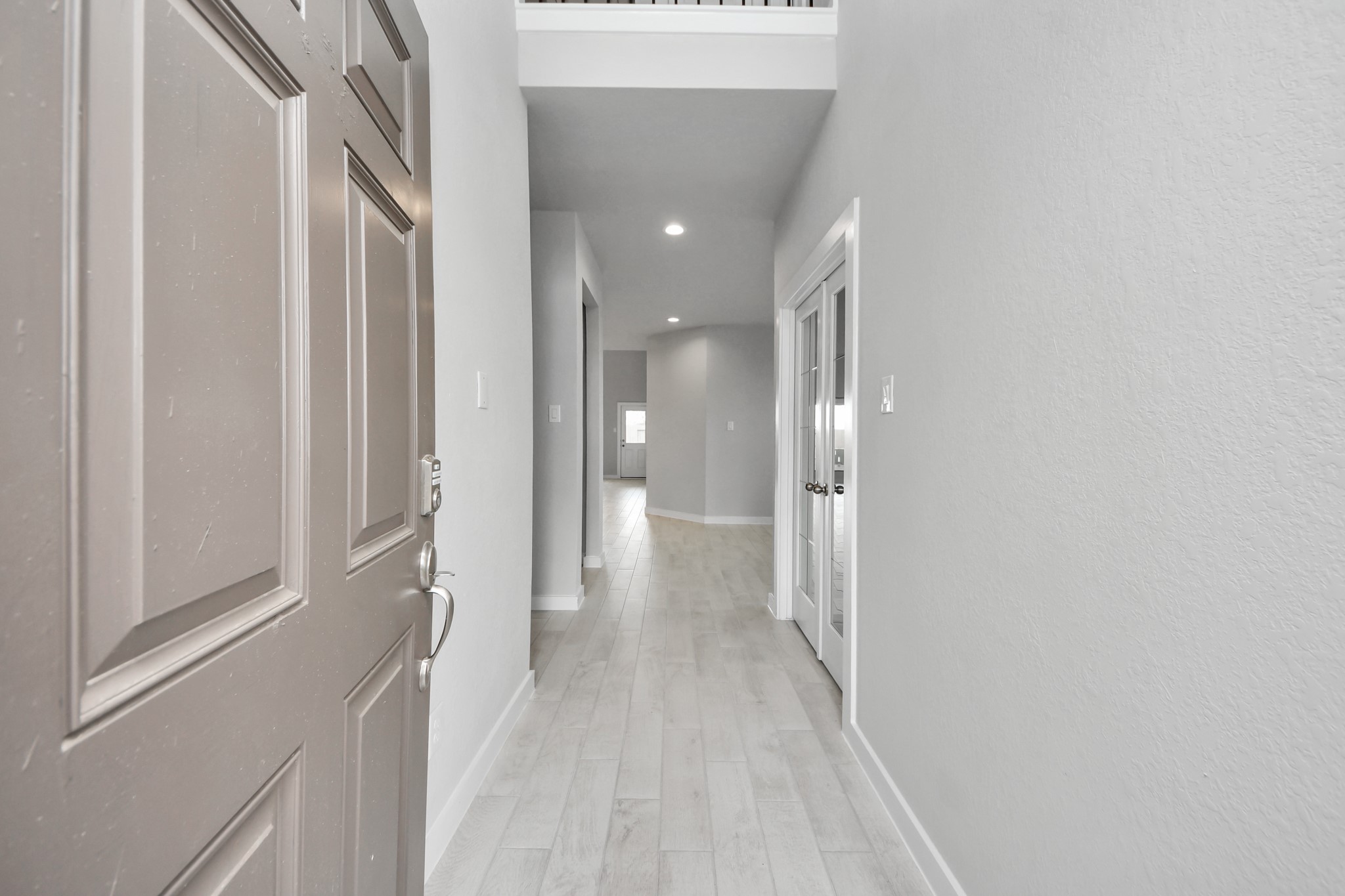 As you step into the threshold of this luxurious home, you'll soon be welcomed by an elegant glass door (to be installed). Inside, soaring ceilings amplify the spaciousness, while the refined wood-look tile flooring and oversized baseboards exude sophistication and charm. Sample photo of completed home with similar floor plan. Actual colors and selections may vary.