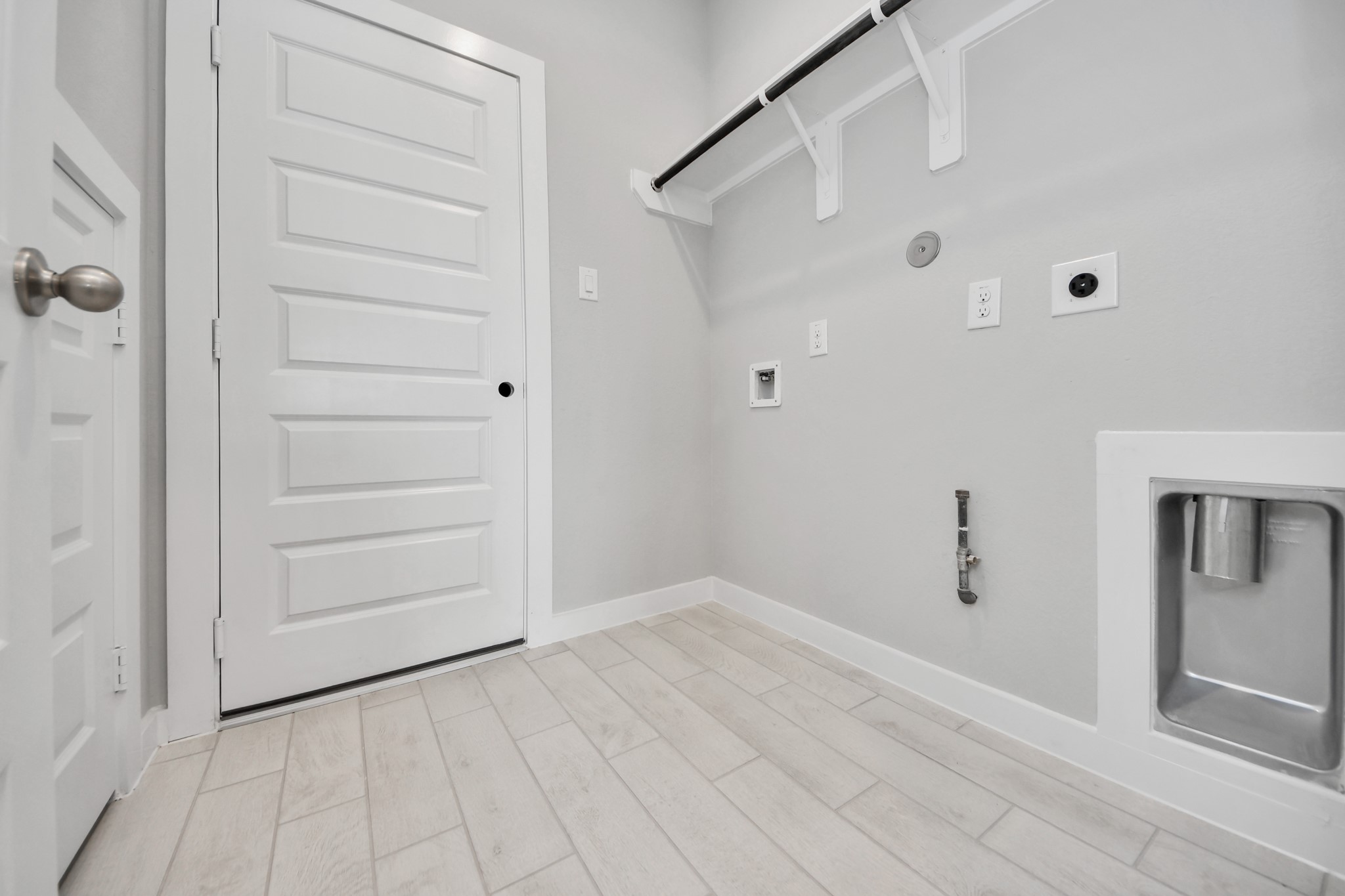 A perfect blend of functionality and comfort. Capture the essence of easy living with a first-floor laundry room, thoughtfully equipped with shelving for effortless organization. Both electric and gas connections available. Sample photo of completed home with similar floor plan. Actual colors and selections may vary.
