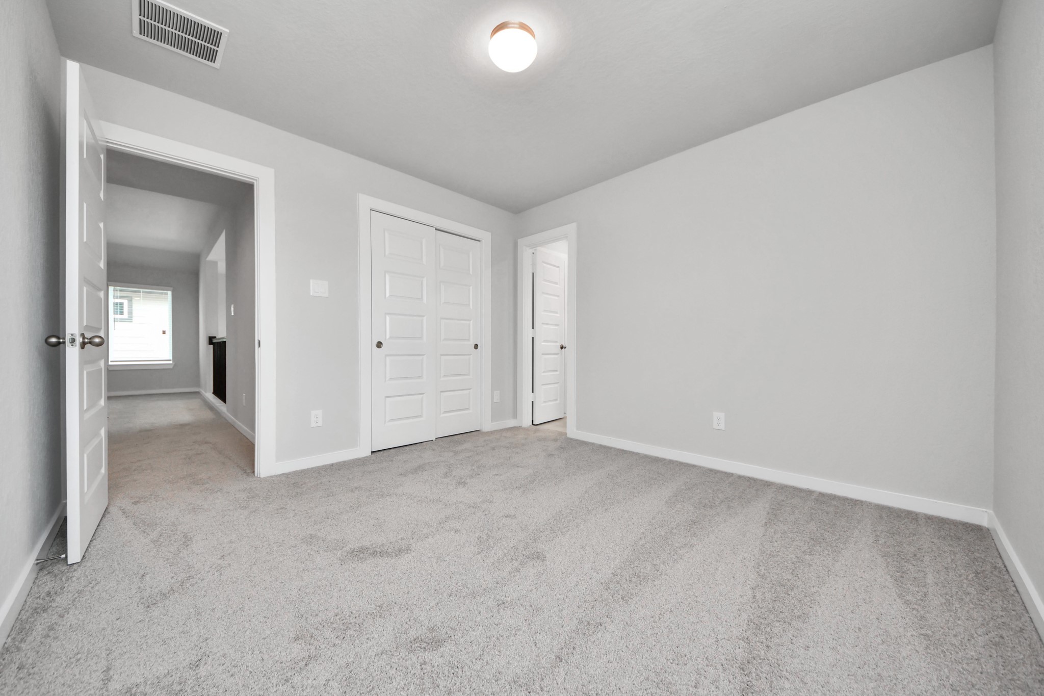 Secondary bedroom features plush carpeting, large windows that let in plenty of natural light, bright paint, and spacious closets. Sample photo of completed home with similar floor plan. Actual colors and selections may vary.