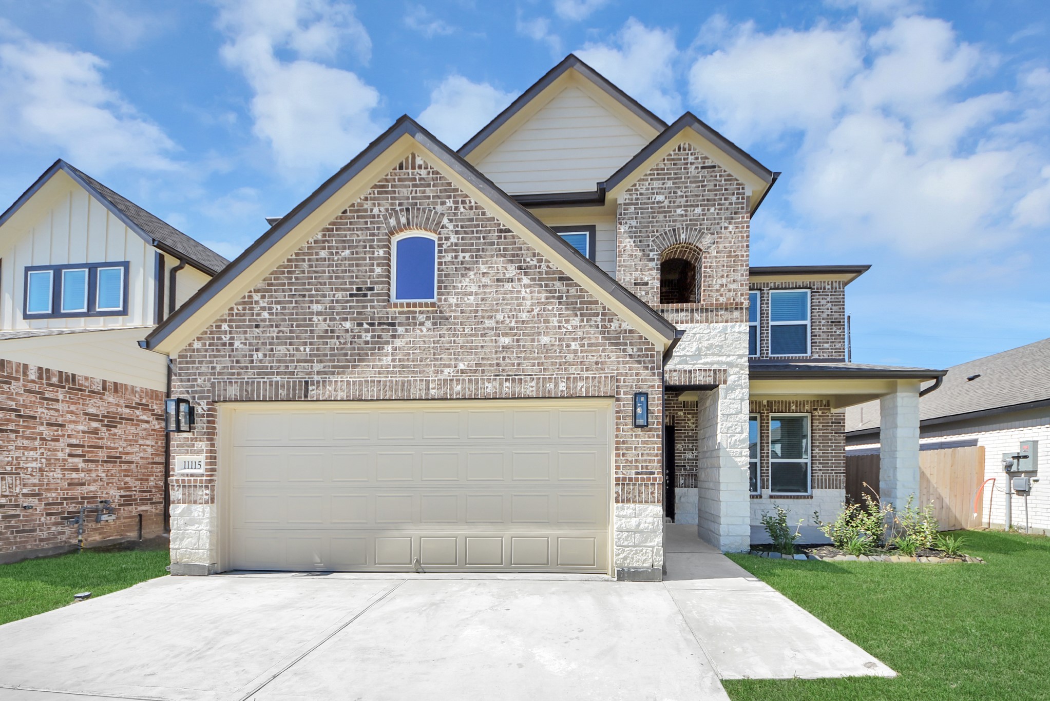 Meticulously maintained yard and lush landscape, paired with a premium elevation featuring captivating brick accents. Modern coach lights add a touch of contemporary elegance to the exterior.