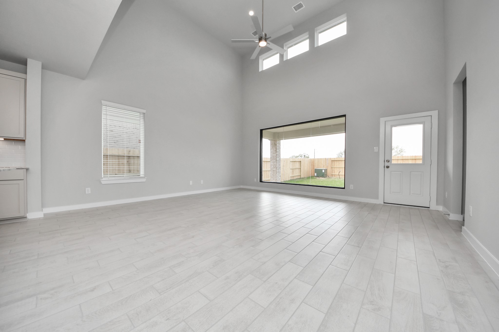 Welcome family and guests to your charming living room! With its high ceilings, recessed lighting, ceiling fan, custom paint, beautiful flooring, and large windows that let in abundant natural light, this room is perfect for gatherings. Sample photo of completed home with similar floor plan. Actual colors and selections may vary.