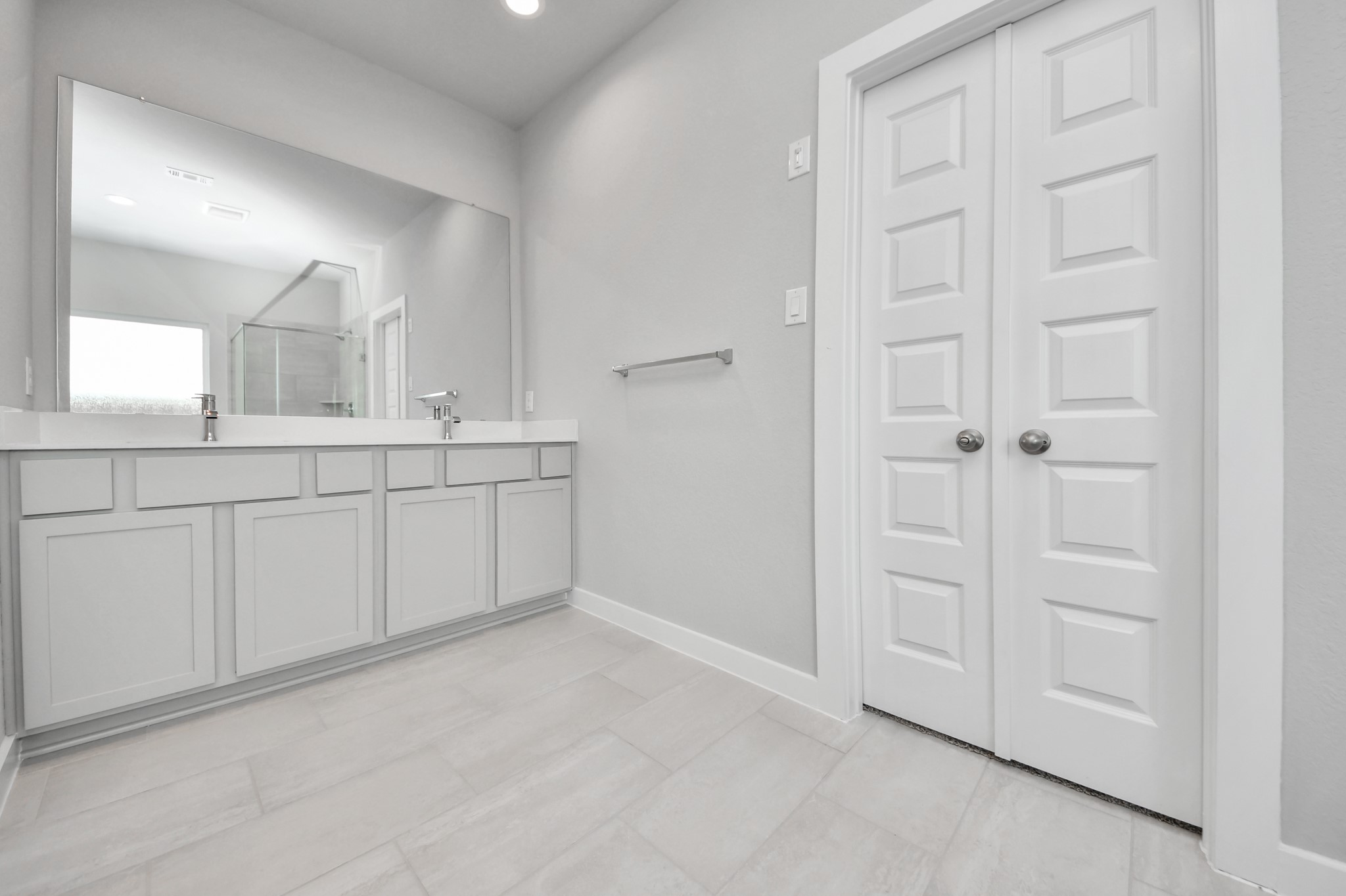 Elevate your daily routine at the elegant vanity, now equipped with double sinks, light countertops, modern hardware, and beautiful recessed lights. Sample photo of completed home with similar floor plan. Actual colors and selections may vary.