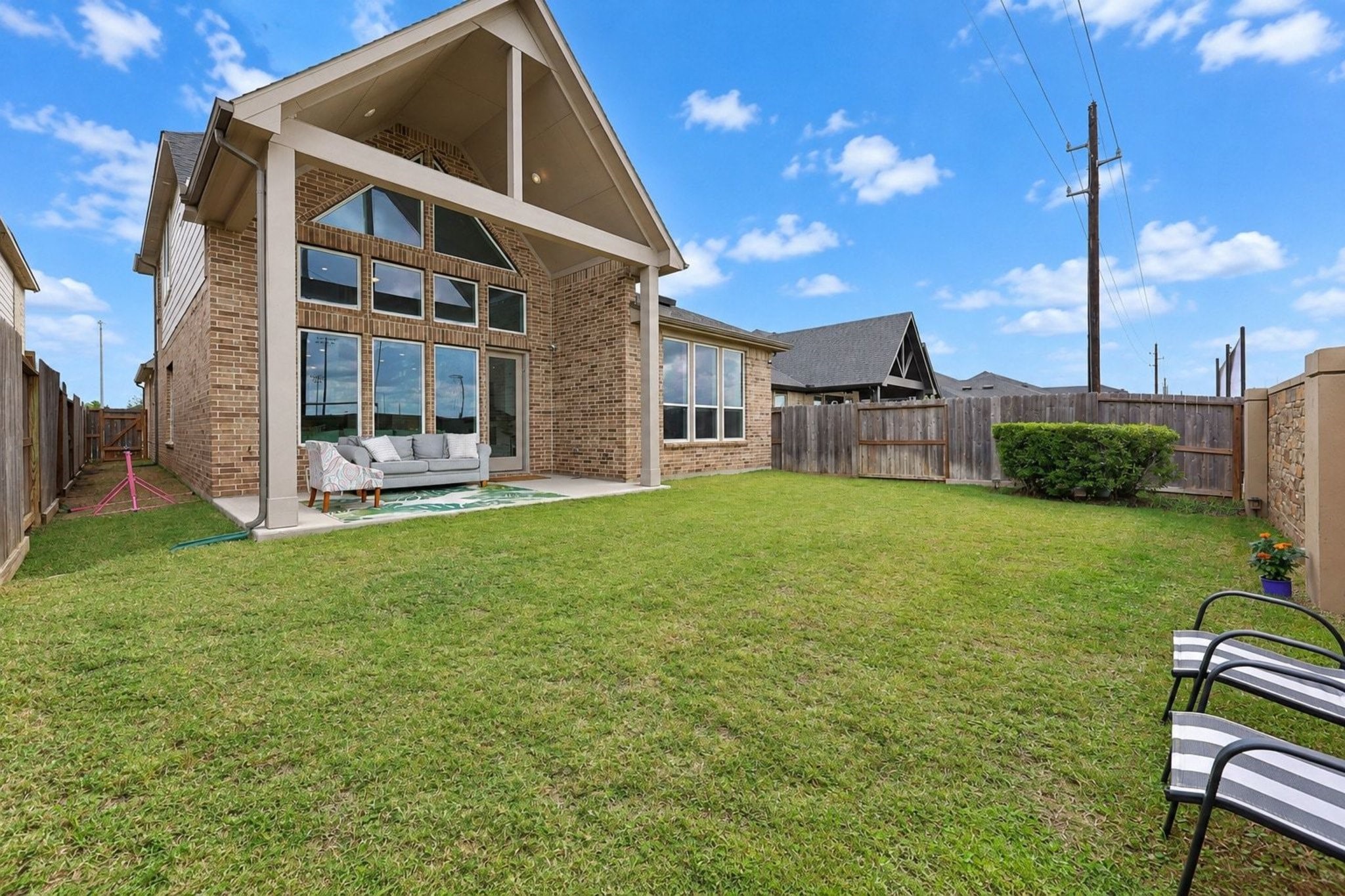 Discover the perfect outdoor retreat with a spacious backyard featuring a covered patio, stylish brick exterior, and ample room for relaxation and entertainment.
