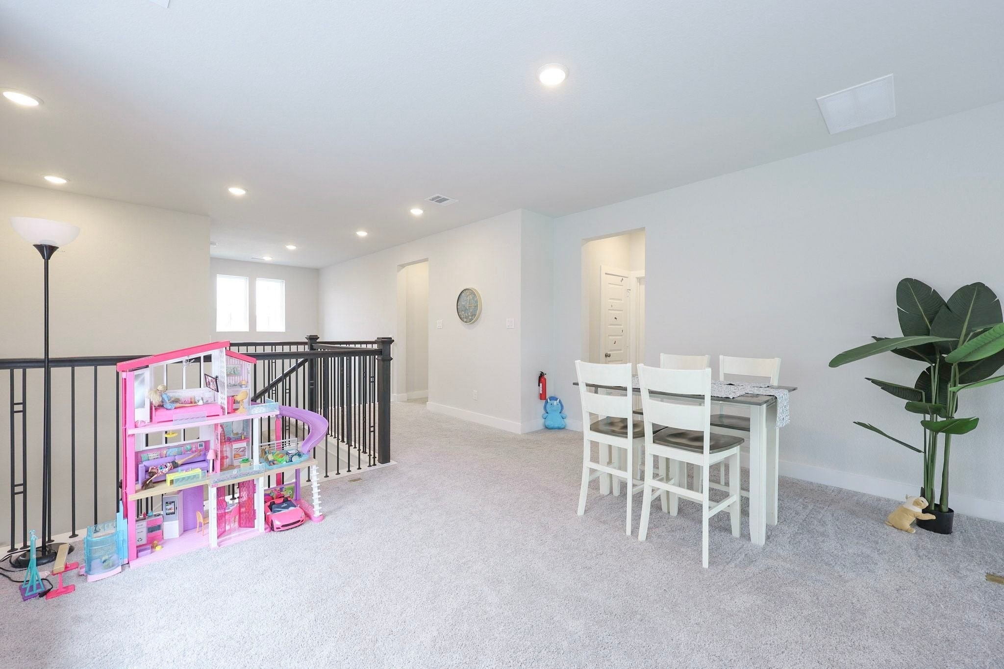 The bright and spacious upstairs landing features plush carpeting and a cozy seating area, offering a versatile spot for play, reading, or relaxation.