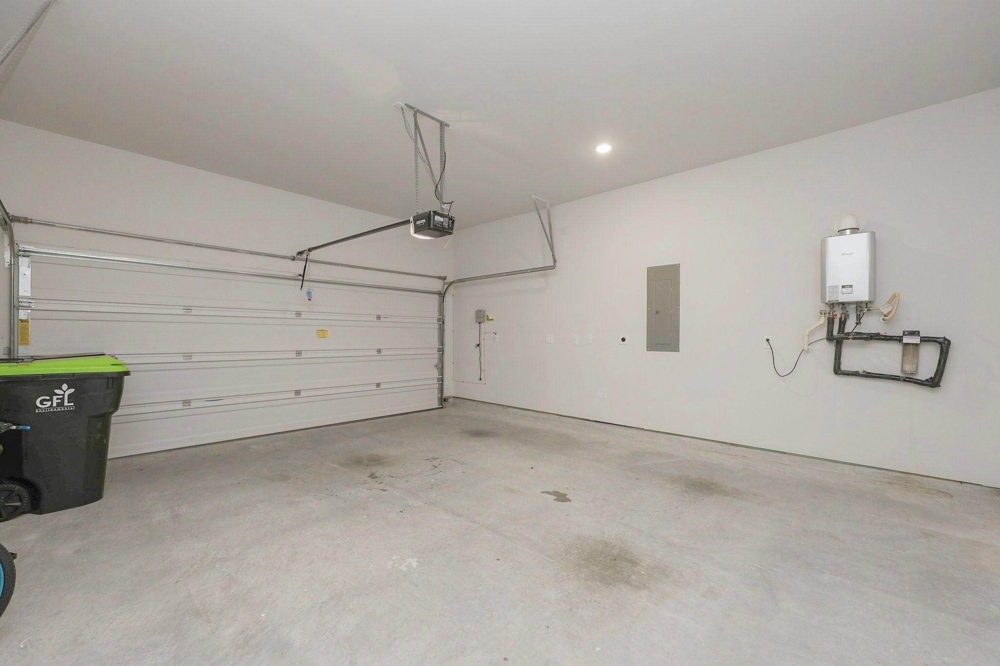 Spacious two-car garage featuring a modern tankless water heater and ample room for storage and the control of the sprinkler system is in the garage. Garage also has an EV charging Socket.