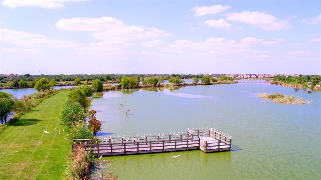 Serene lake views in cross creek ranch with a wooden dock, surrounded by lush greenery and open skies, perfect for relaxation and nature lovers.