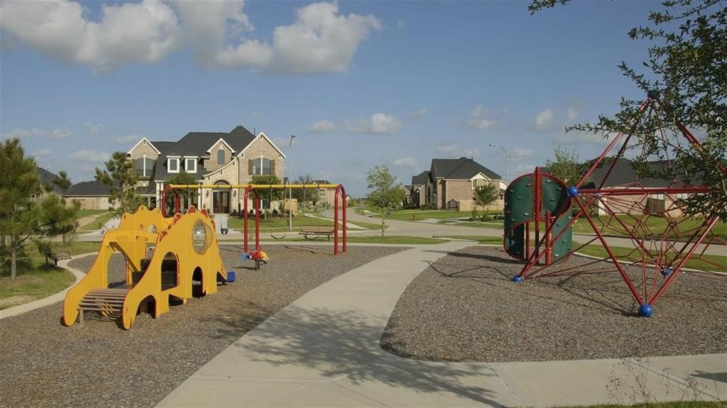 The neighborhood playground with modern equipment, surrounded by well-maintained homes and lush greenery, perfect for family living.