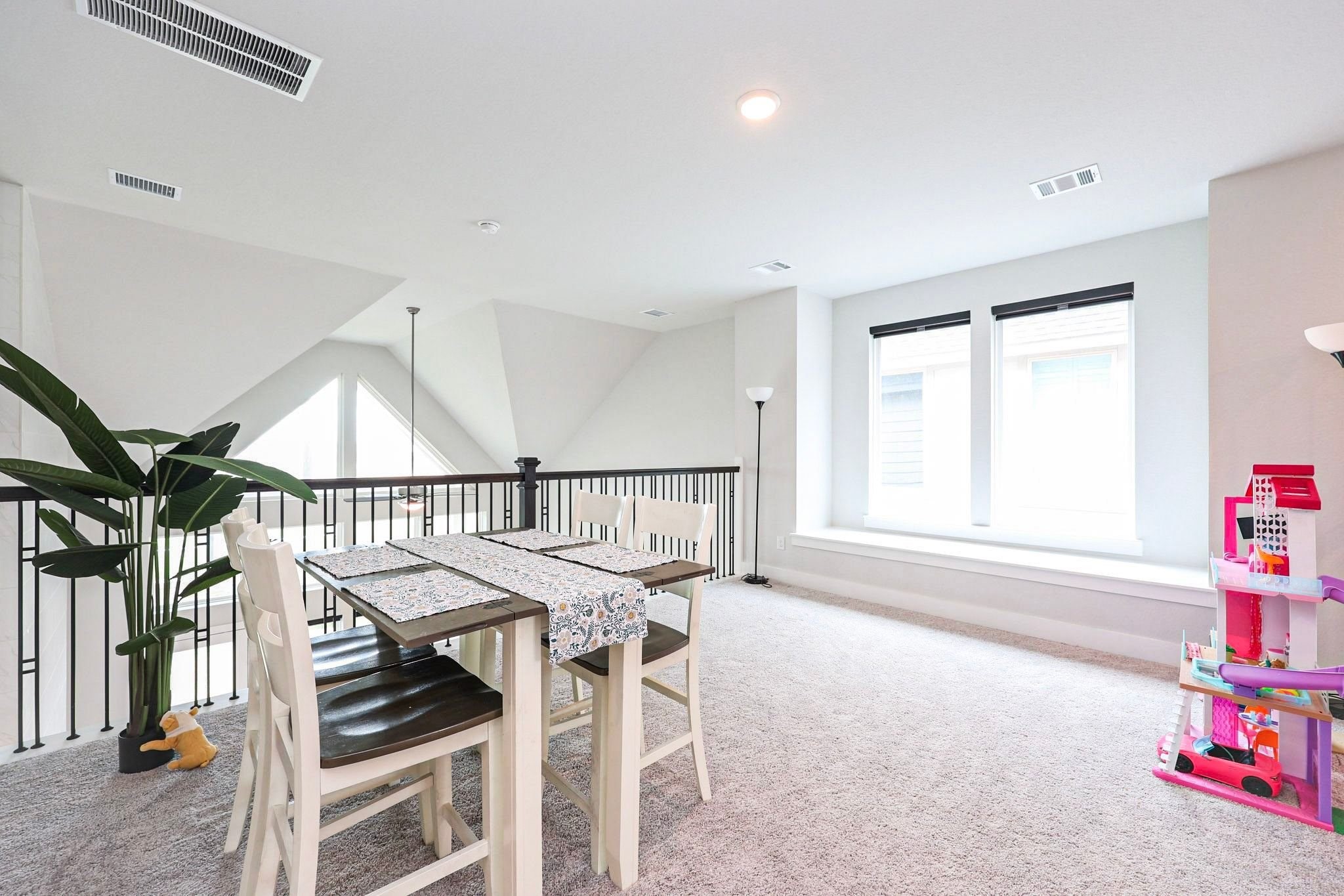 The bright and airy second-floor game room offers versatile space for recreation or entertaining, with large windows that welcome abundant natural light and plush carpeting for added comfort.
