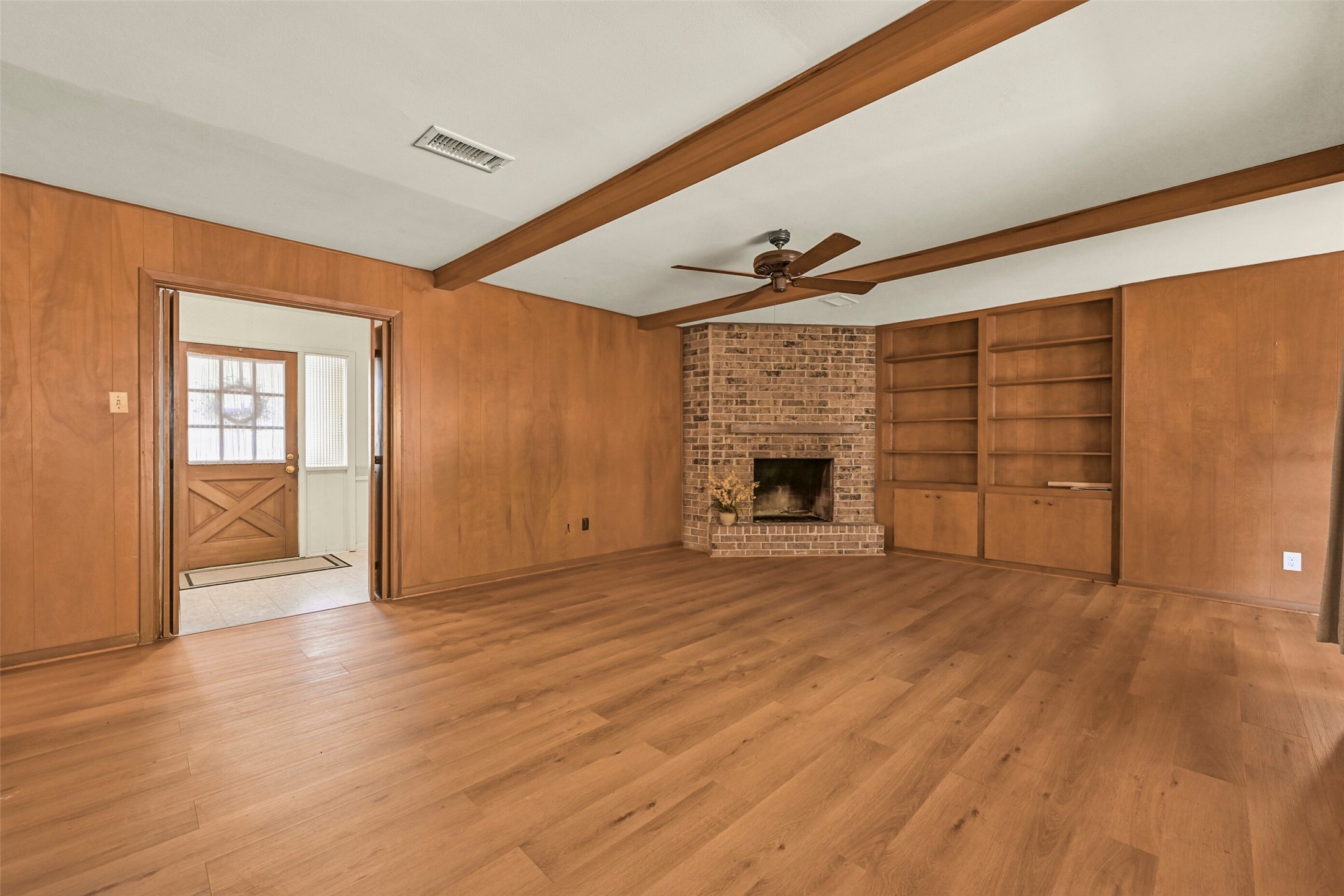 Another view of the den showing the fireplace and built in bookshelves