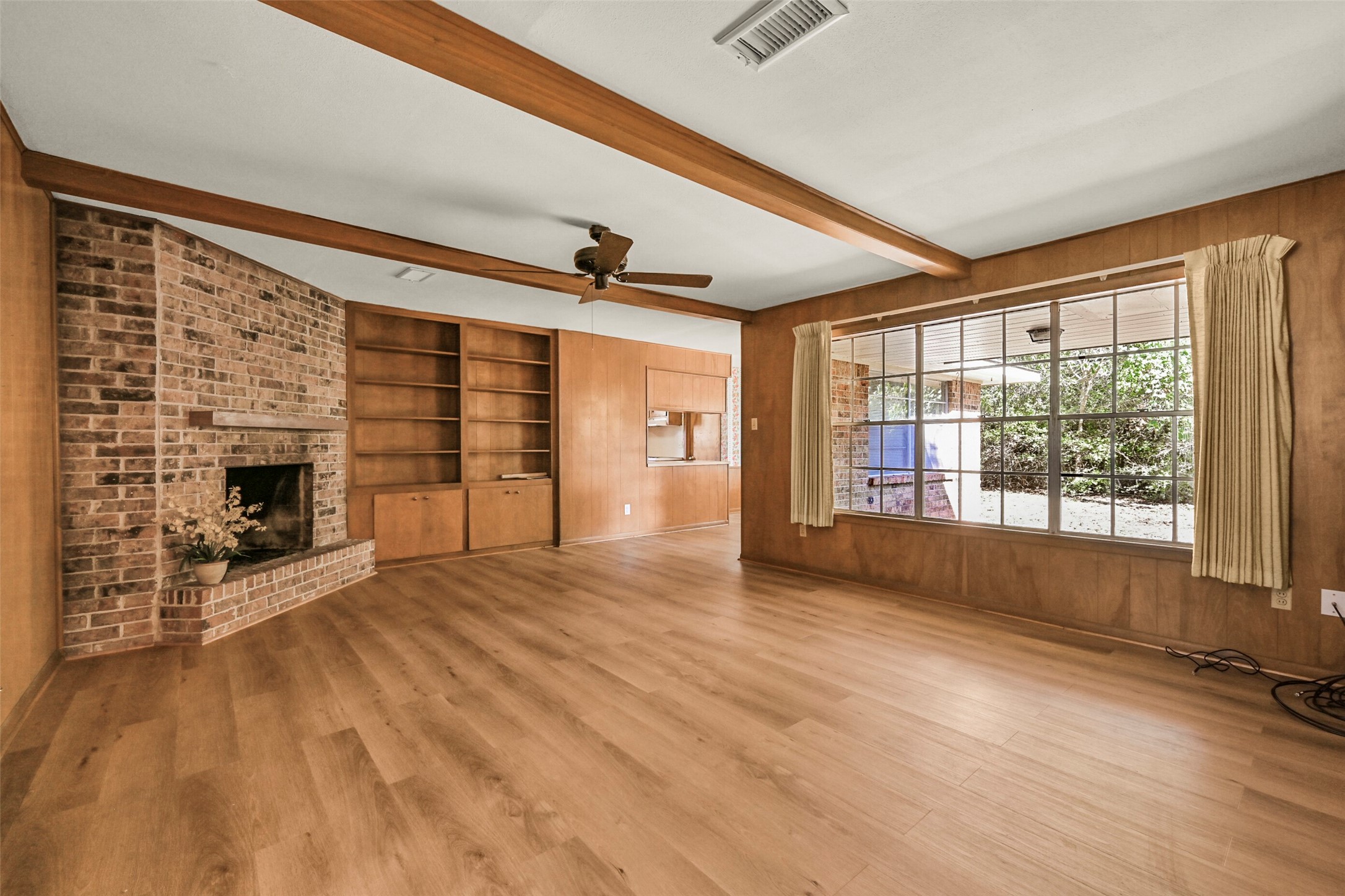 Cozy den with luxury vinyl plank flooring and a gas fireplace
