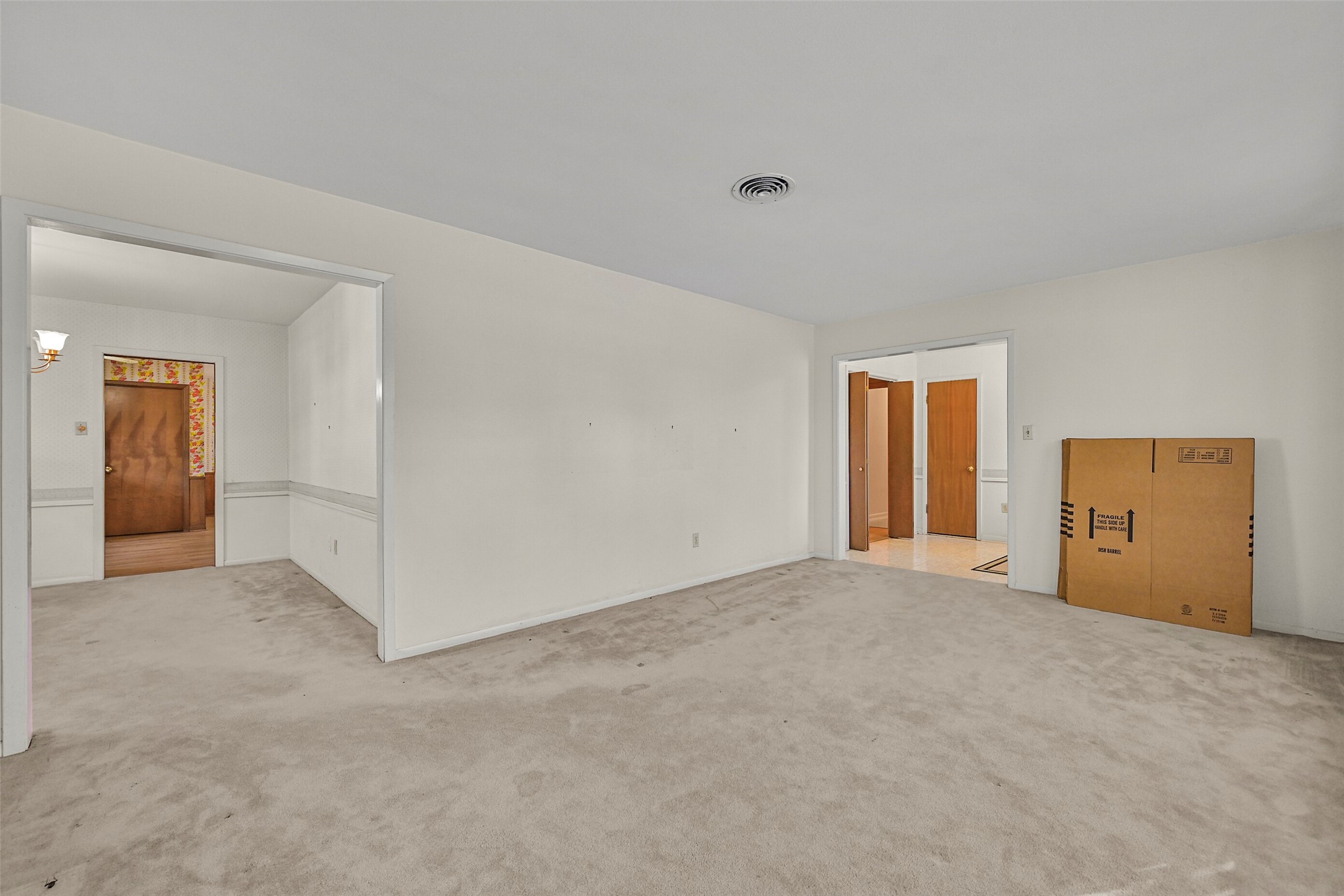 View from the living room looking into the dining area as well as the front entry way