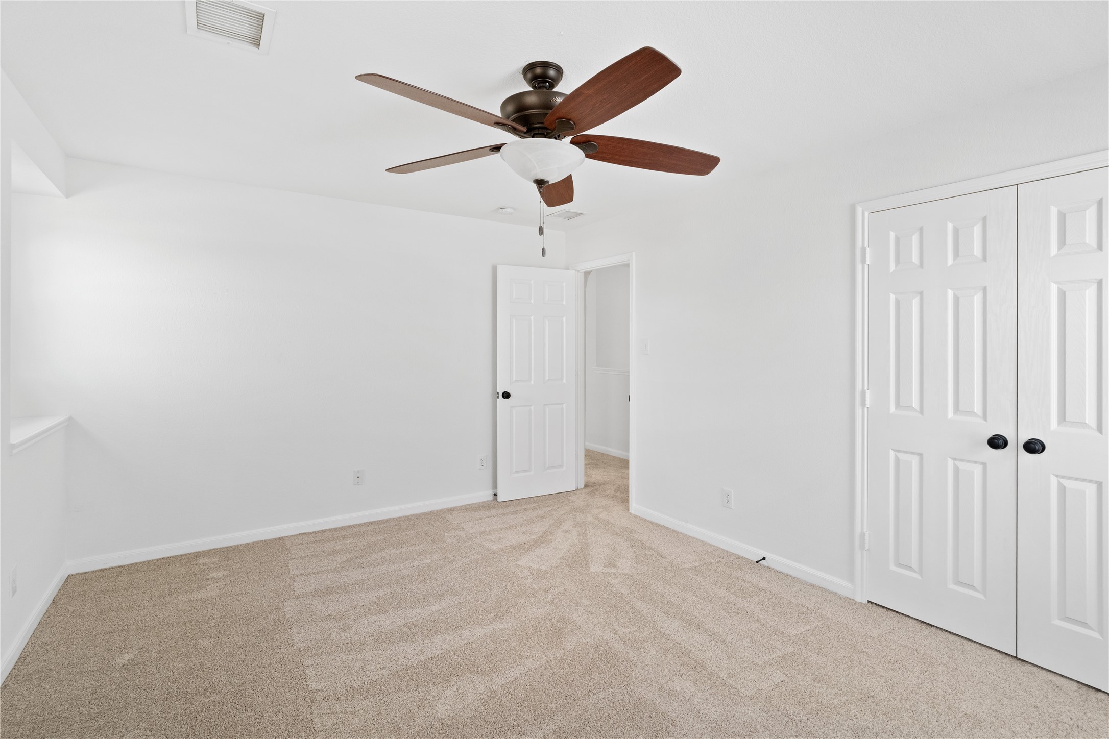 Bedroom  Another view showcases the rooms closet storage, clean neutral palette, and ample floor space for flexible furniture placement.