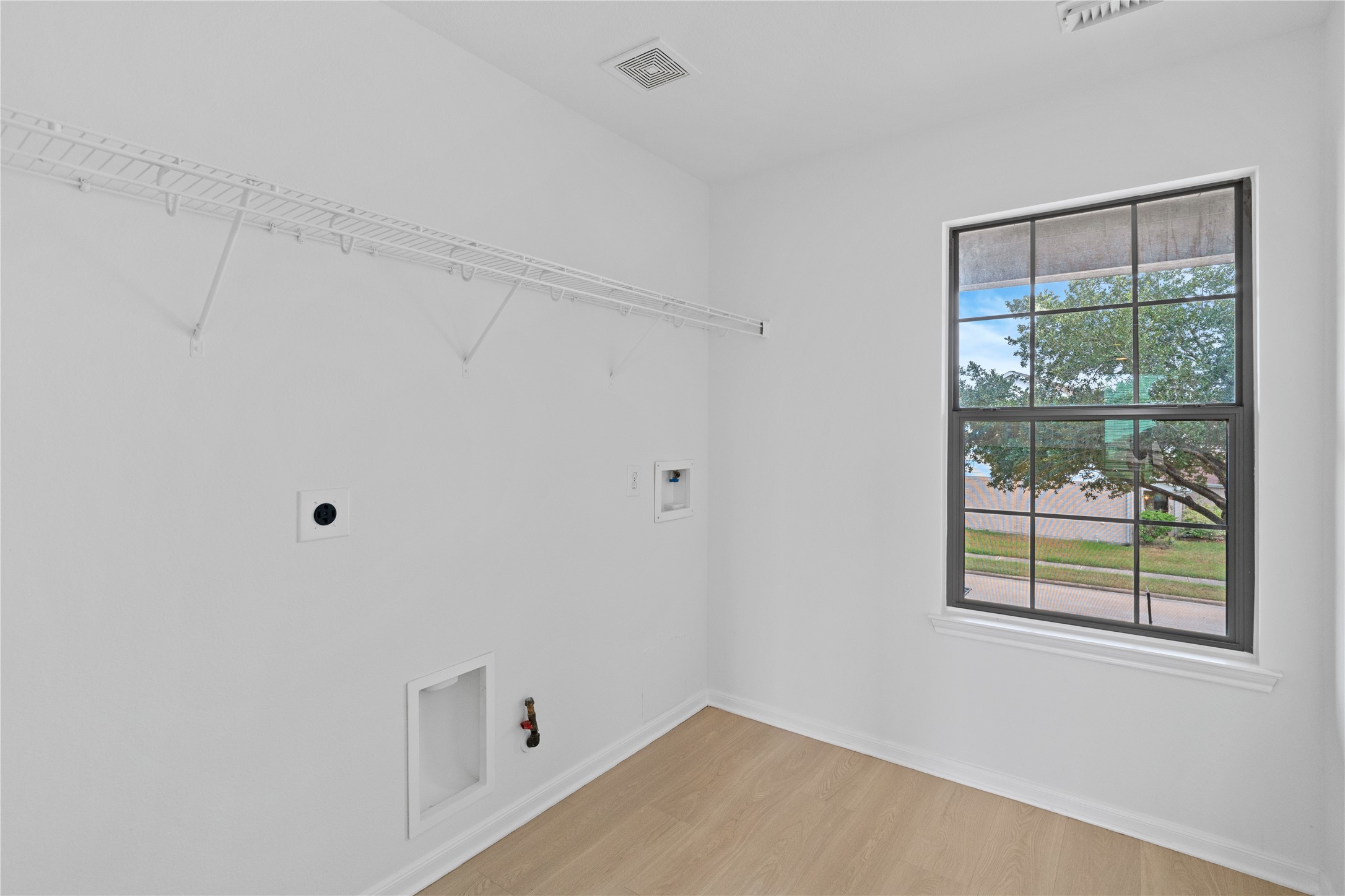 Laundry Room  Dedicated laundry space with washer and dryer connections, built-in wire shelving, a window for natural light, and easy-care flooring.