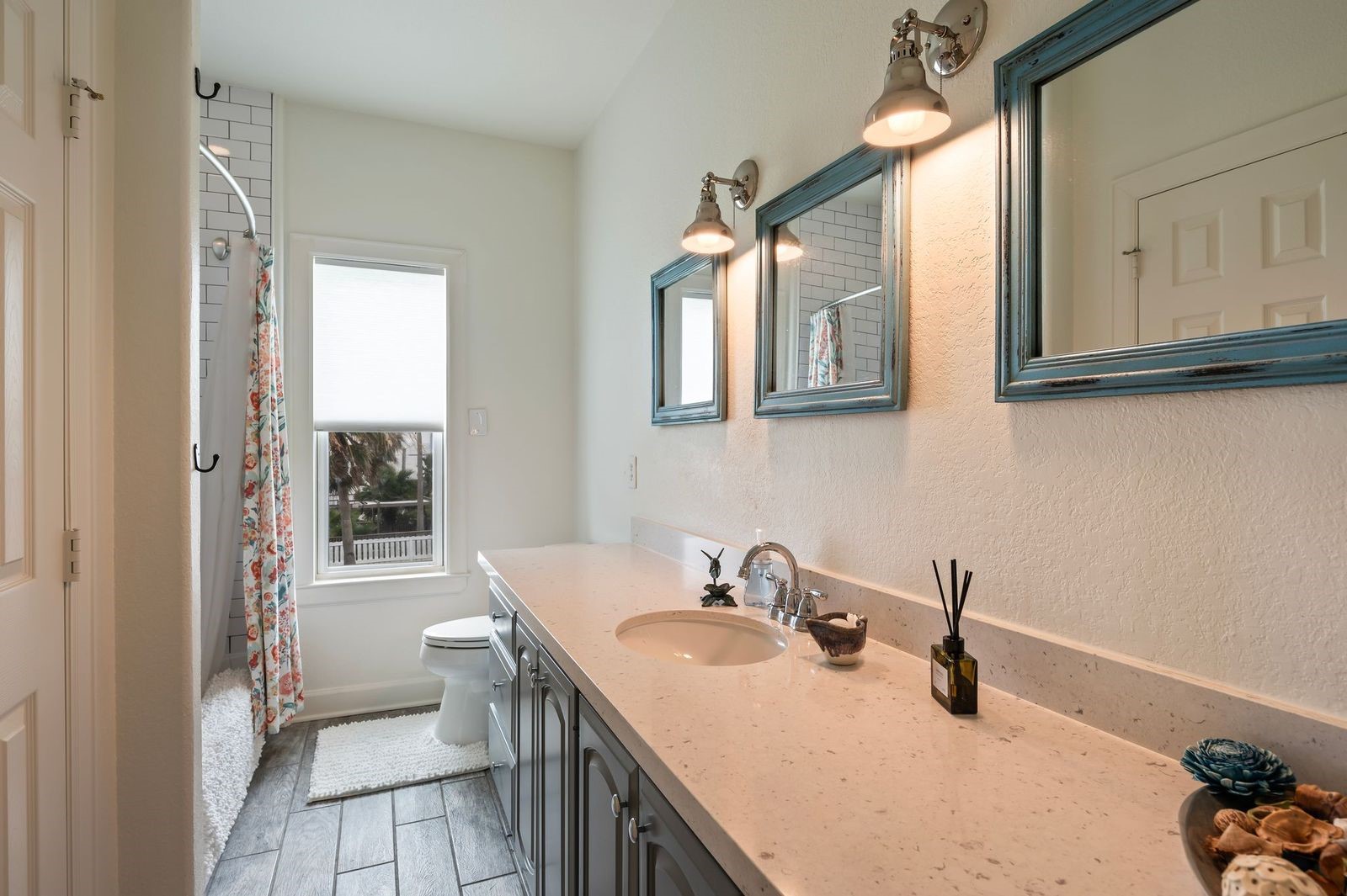 Detailed view of the spacious secondary bathroom featuring undermount sink, linen storage and custom fixtures.