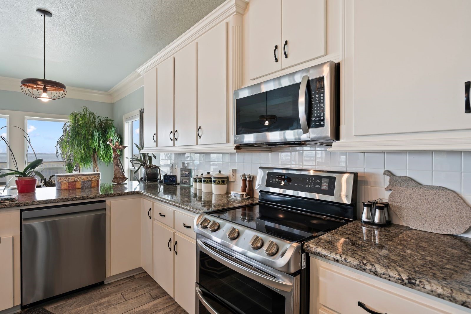 Designer Style Living with double ovens, granite countertops and tile backsplash.