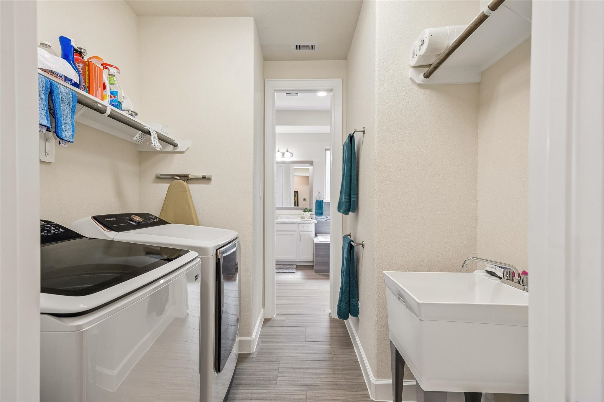 Laundry room with double access, from hall and primary bath.