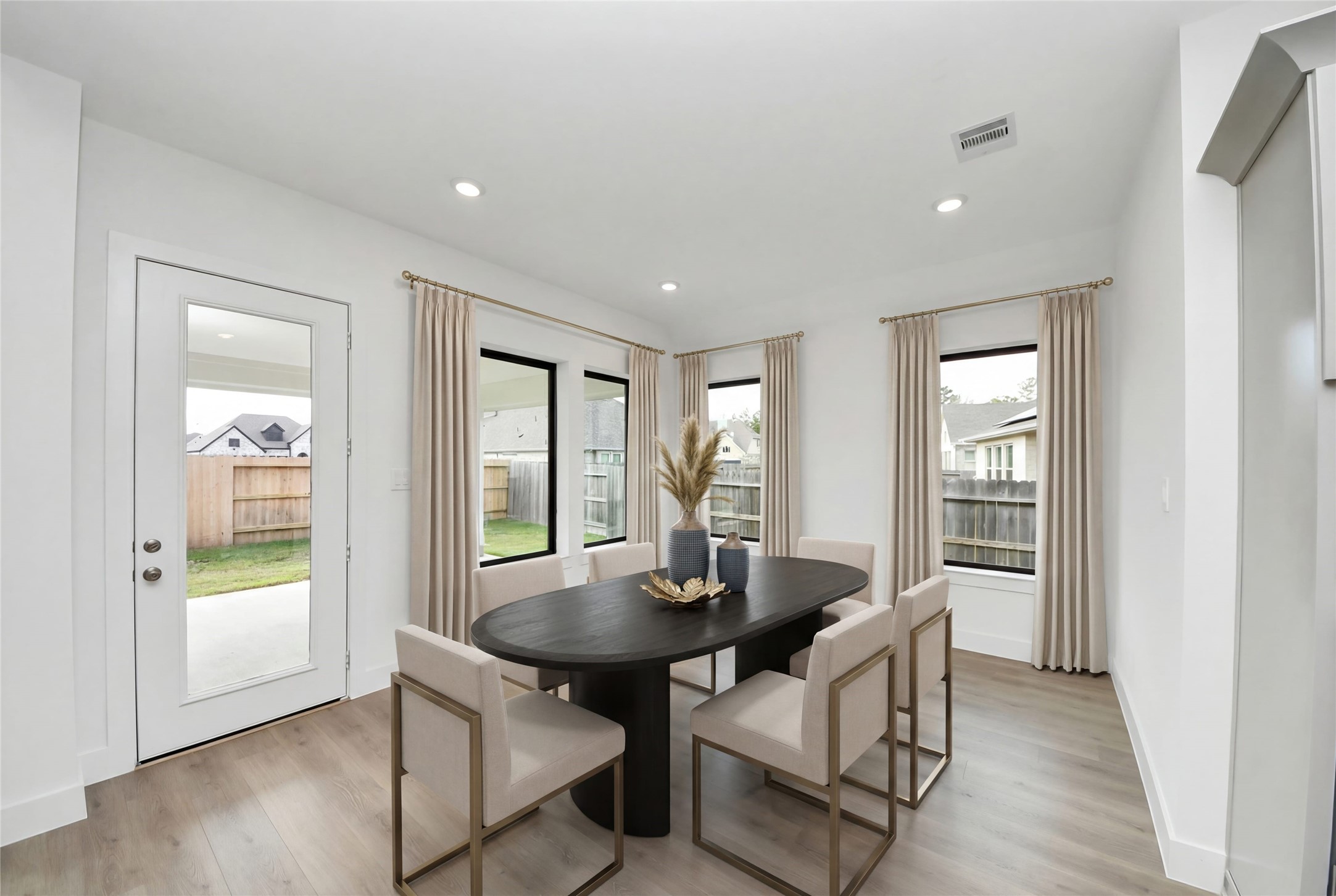 The breakfast room is filled with natural light and features high ceilings, recessed lighting, and expansive windows.