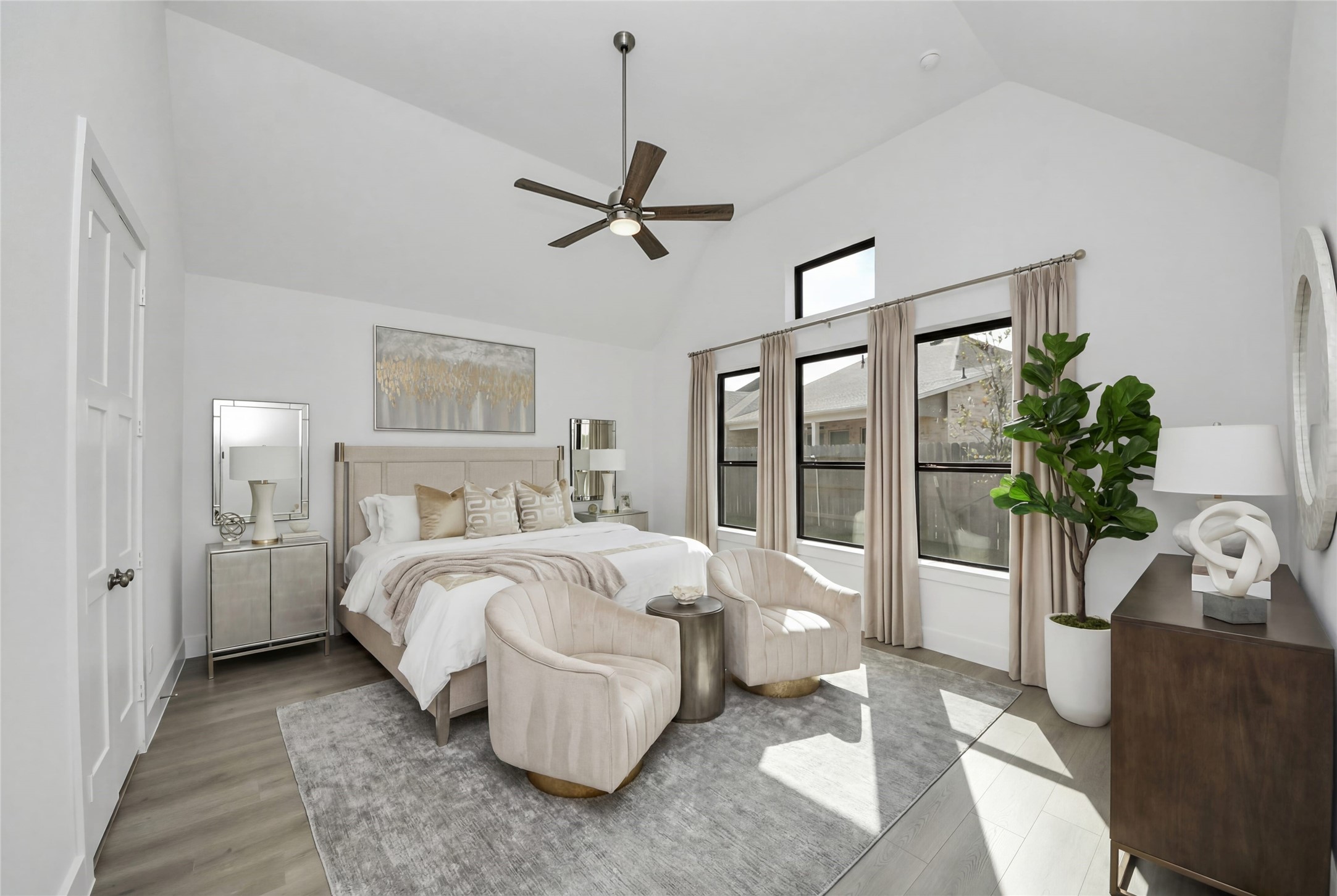 Relax and unwind after a long day in this impressive primary suite! This generously sized room offers laminate flooring, neutral-toned paint, high ceilings with a ceiling fan, and large windows for added comfort and tranquility.