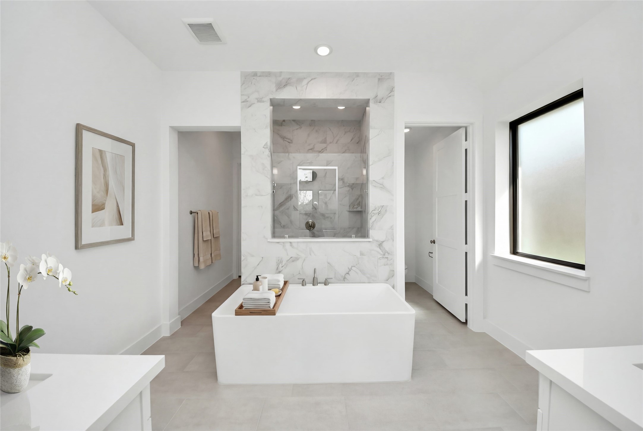 The centerpiece of this contemporary primary bath is the deep, freestanding bathtub, offering an ideal spot for relaxation with a unique view into the walk-in shower.