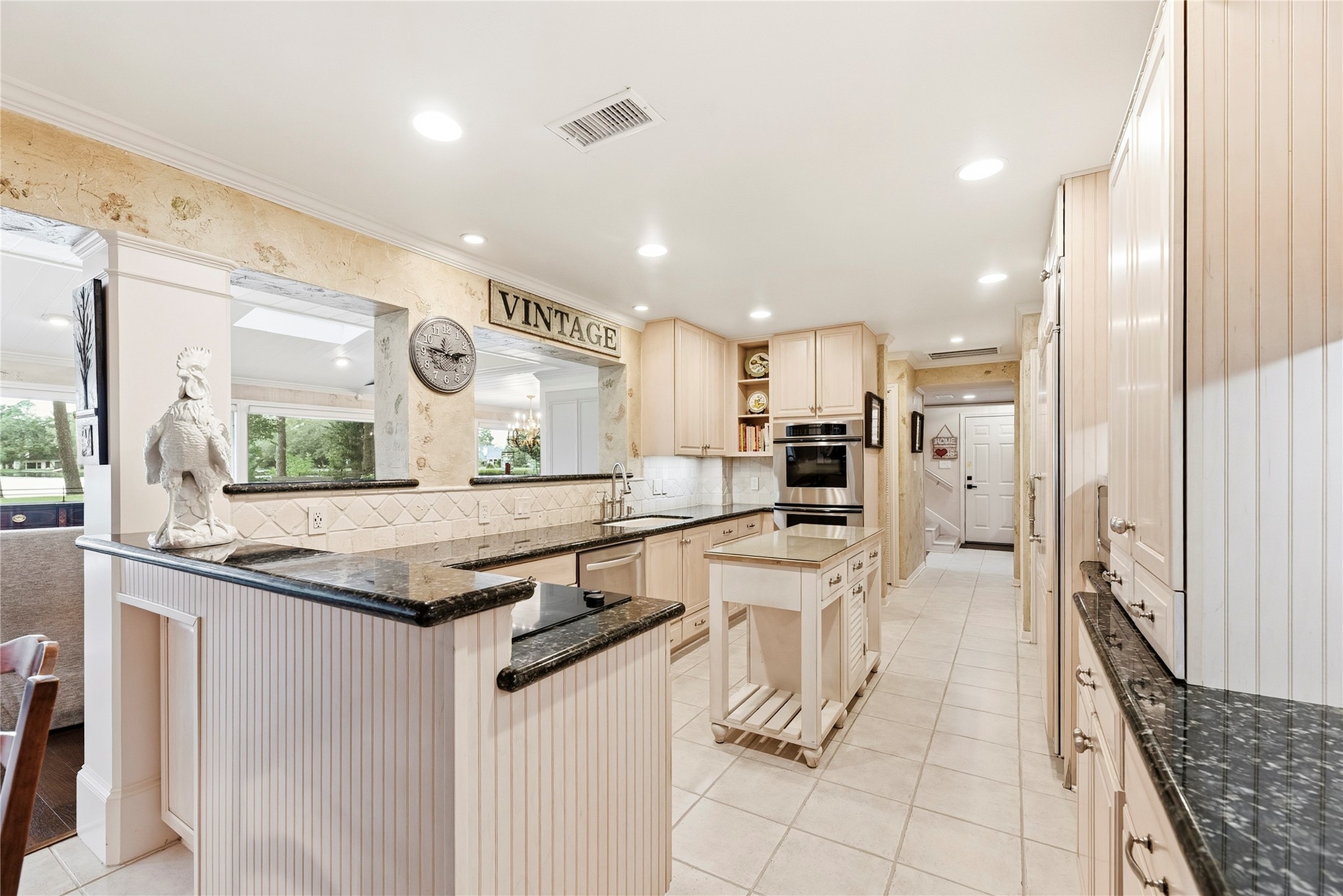 Timeless kitchen complete with granite countertops, Thermador double ovens, wood-paneled sub-zero refrigerator, recessed lights and more.