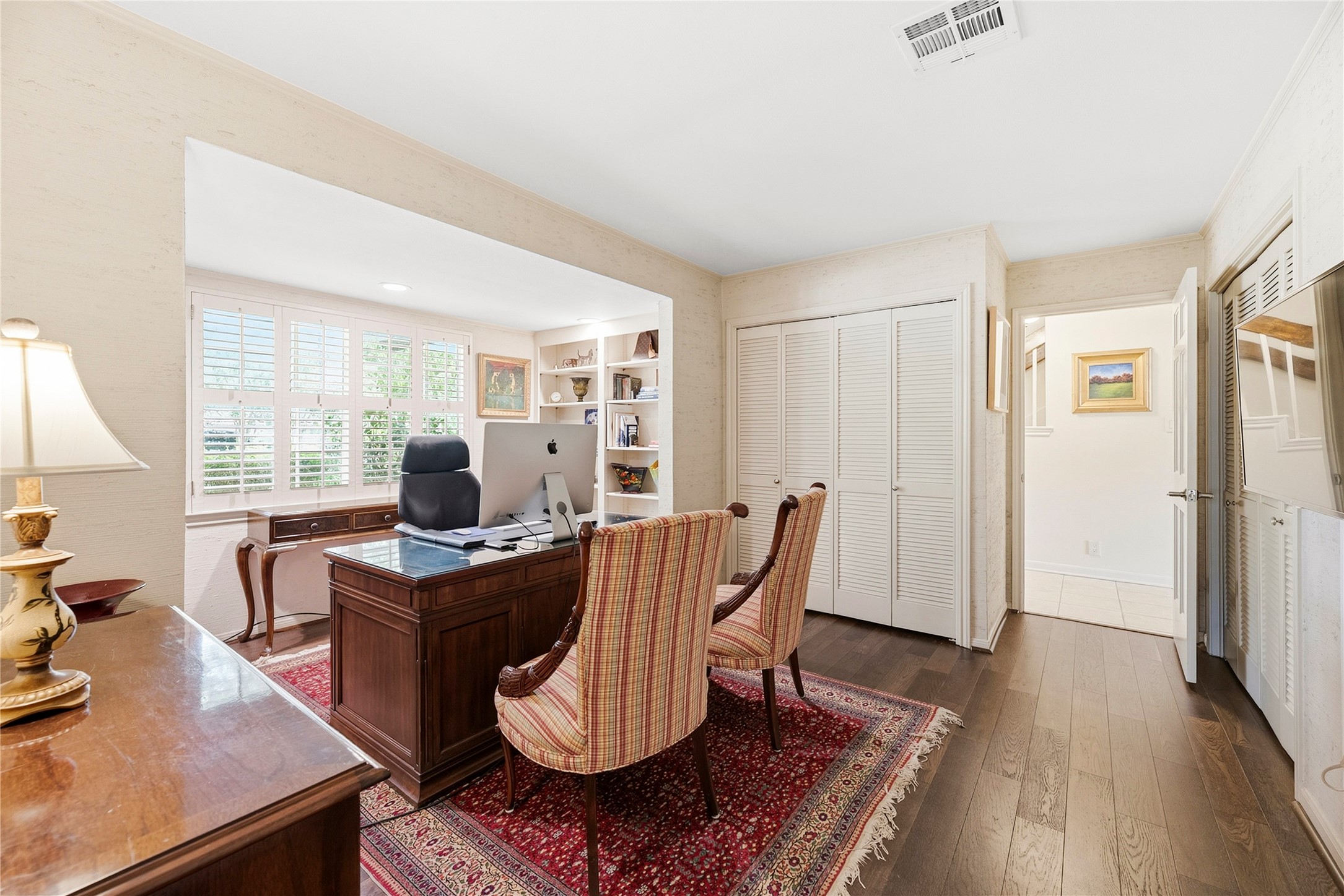 First floor bedroom, complete with large windows and two closets, neutral paint, and beautiful wood floors - currently used as an office.