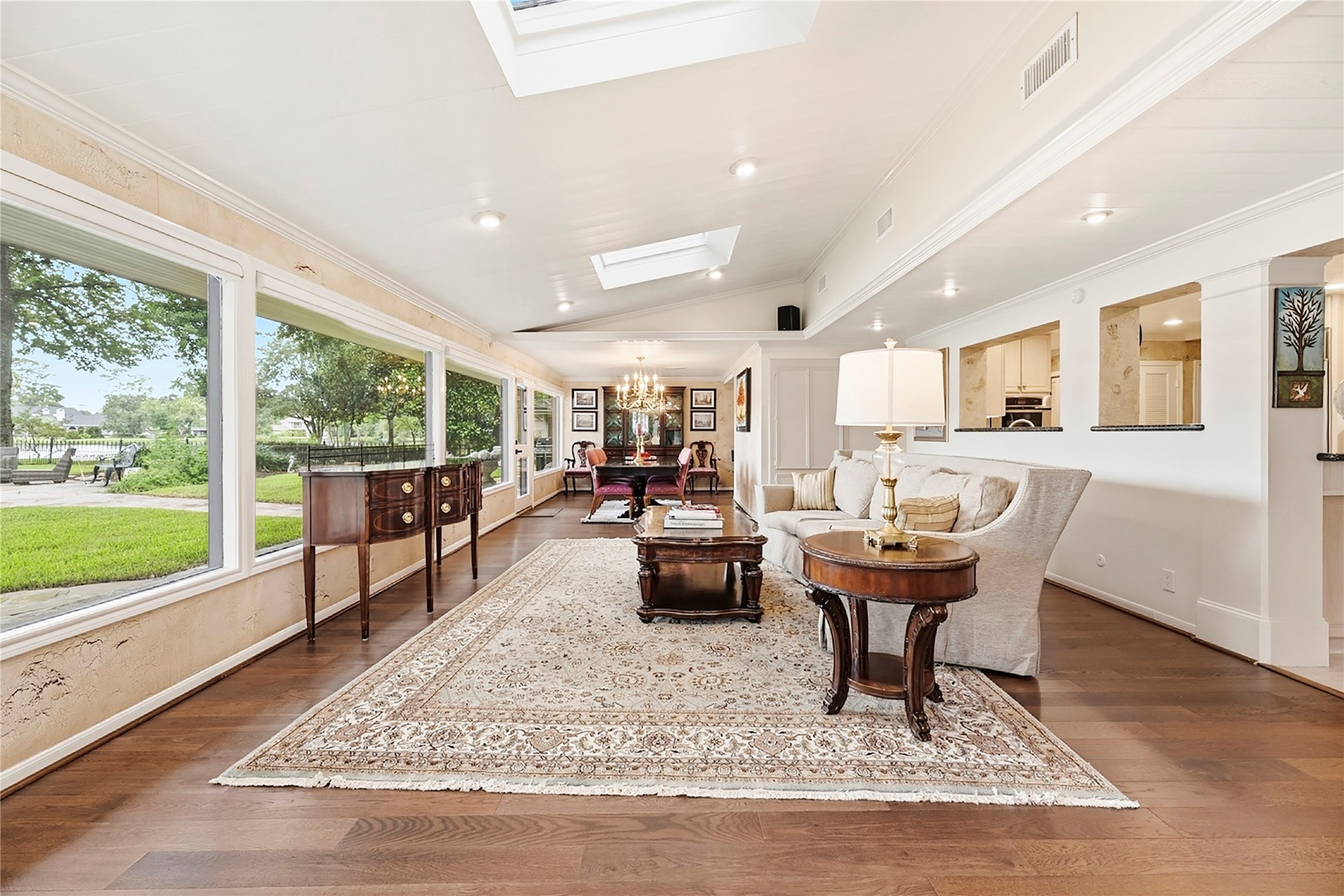 Heart of the home with a wall of windows, beautiful wood floors, sky lights, and recessed lights.