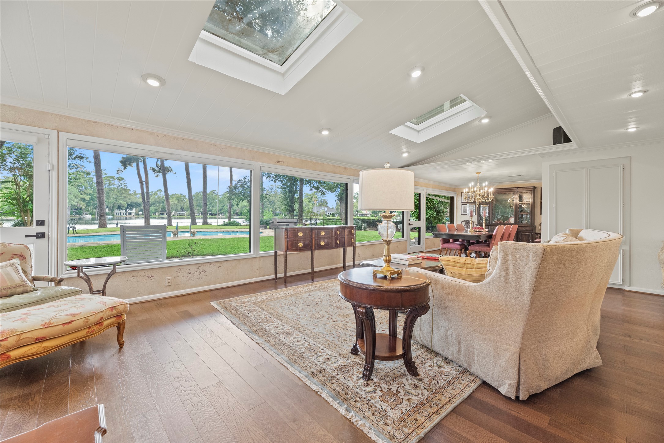 Heart of the home with a wall of windows, beautiful wood floors, sky lights, and recessed lights.
